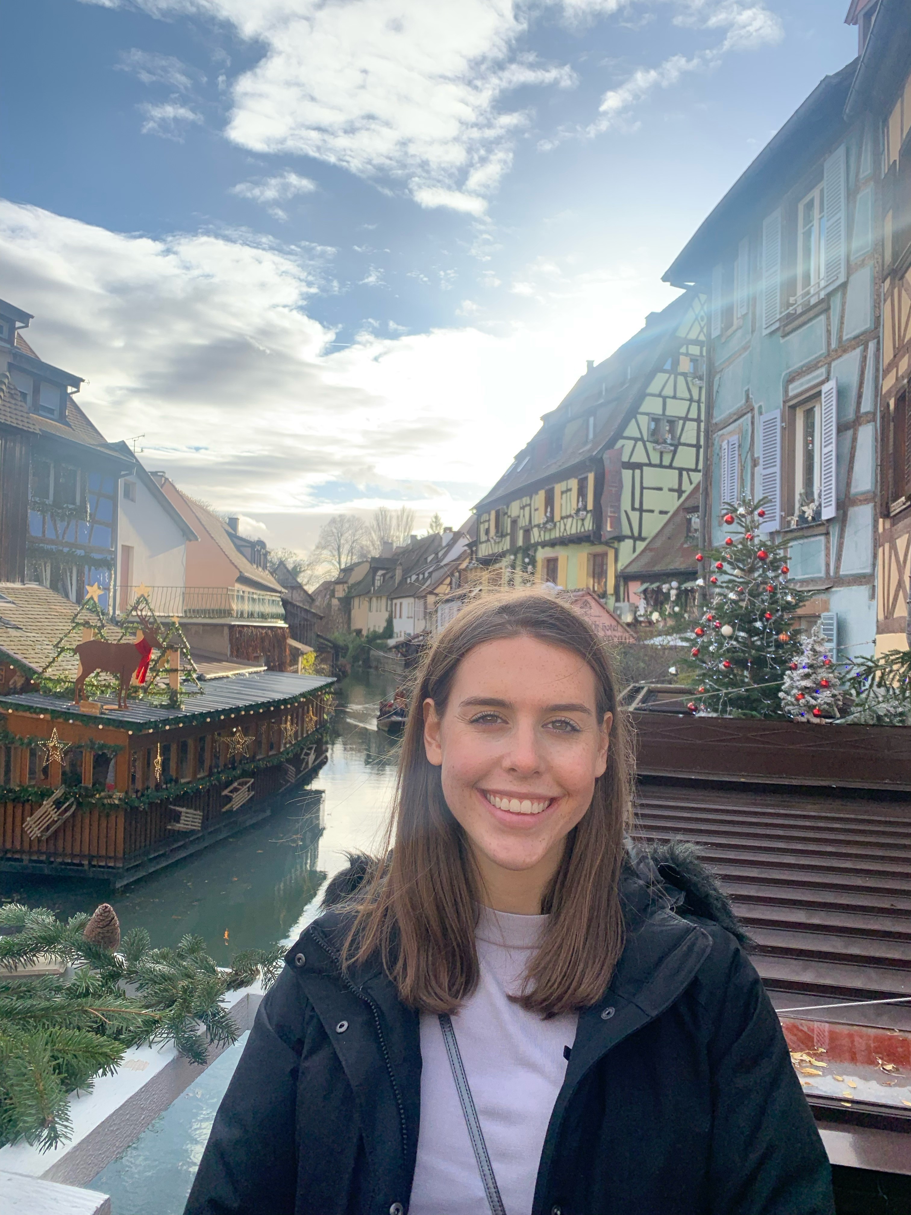 A woman student posing in front of a canal in France during study abroad.