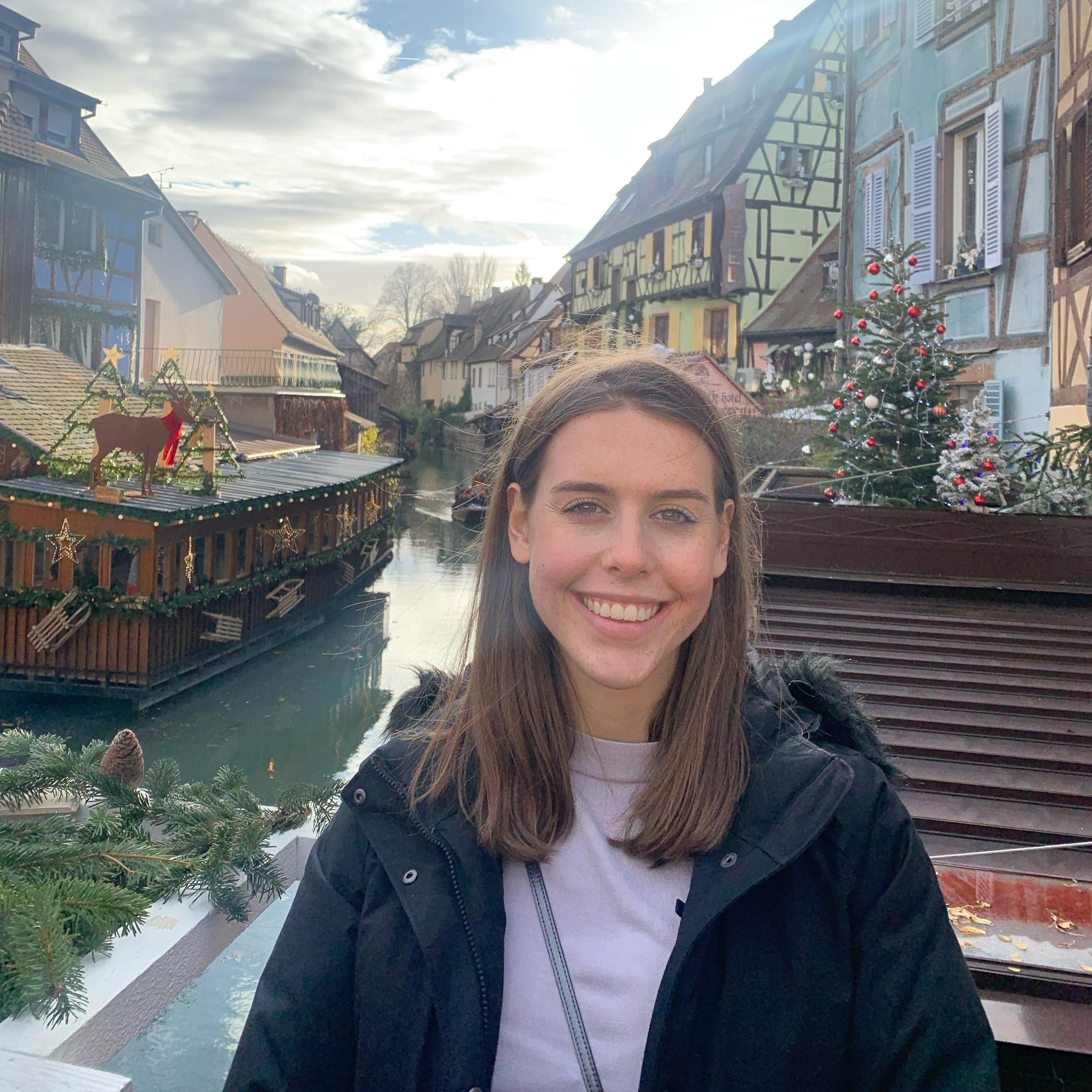 A woman student posing in front of a canal in France during study abroad.