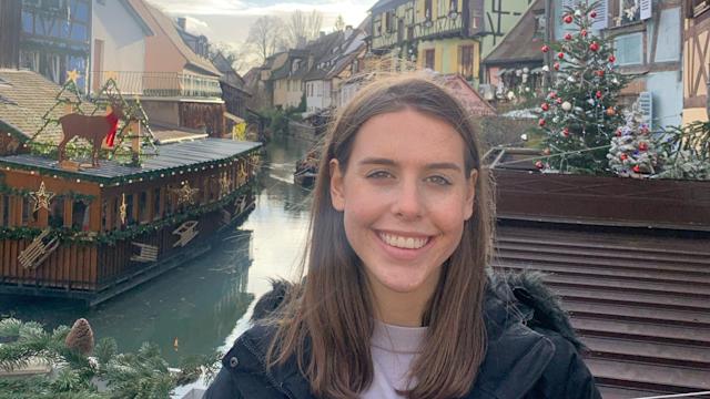 A woman student posing in front of a canal in France during study abroad.
