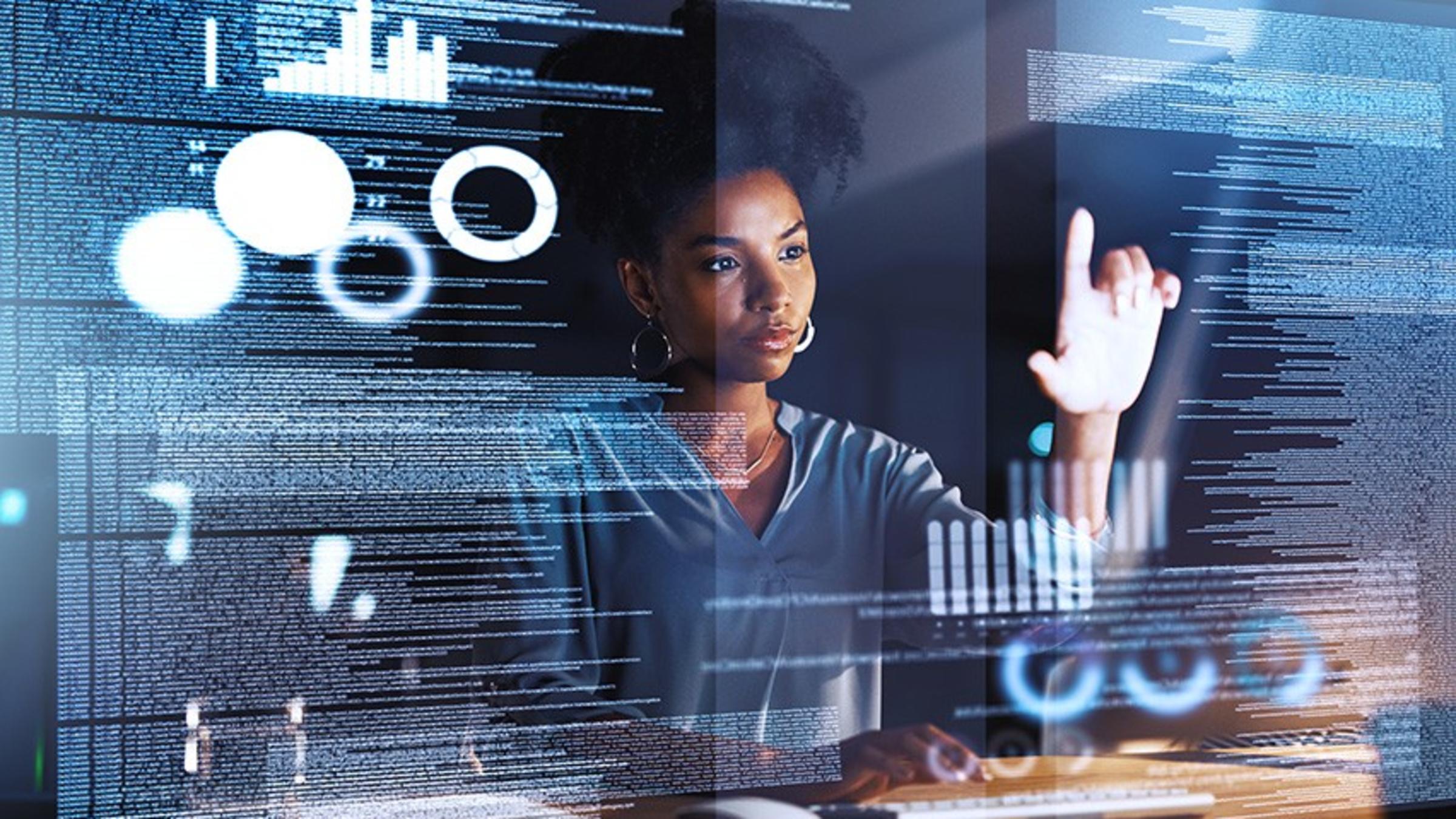 Woman looks at code on translucent touchscreen.