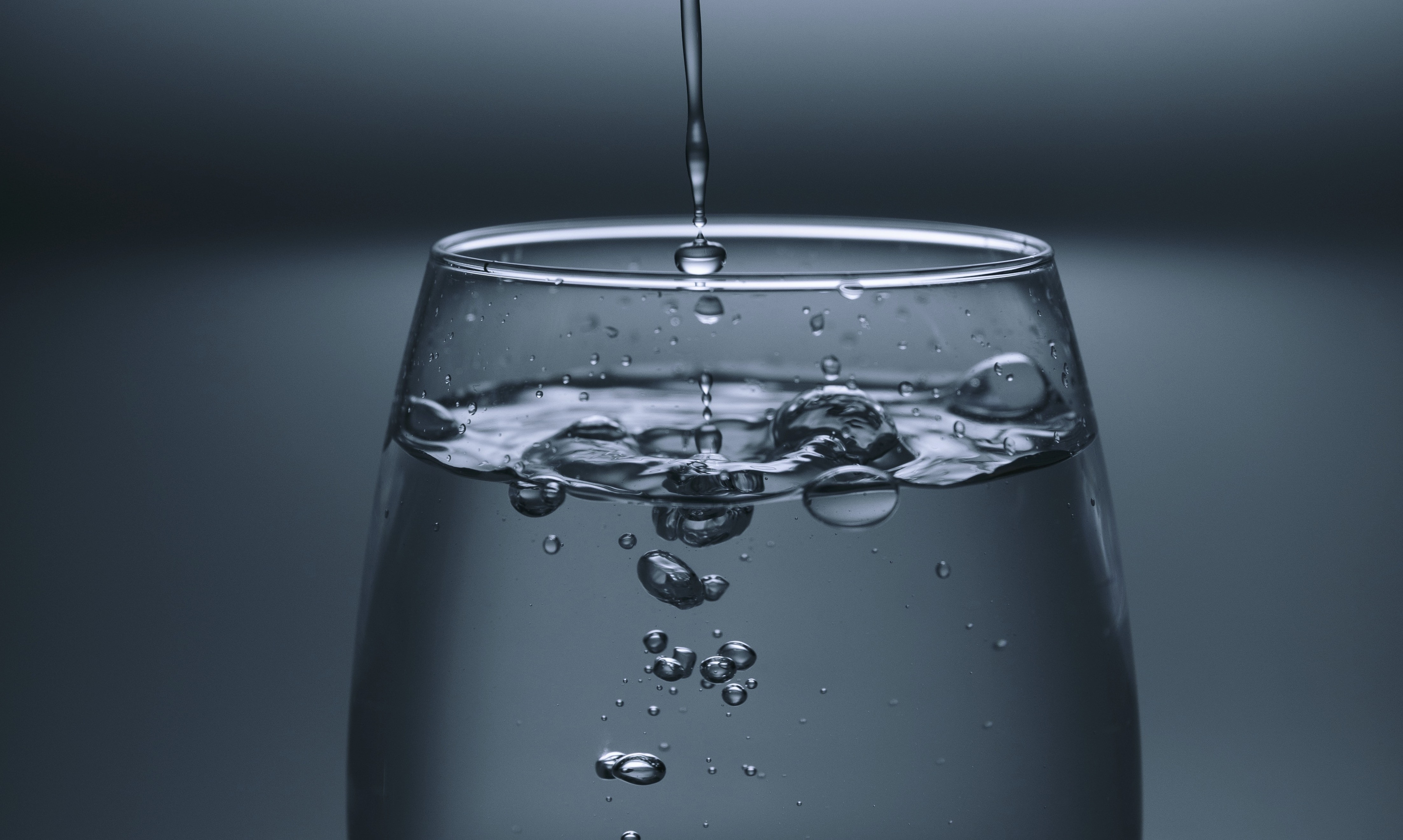 A glass of water being filled up.