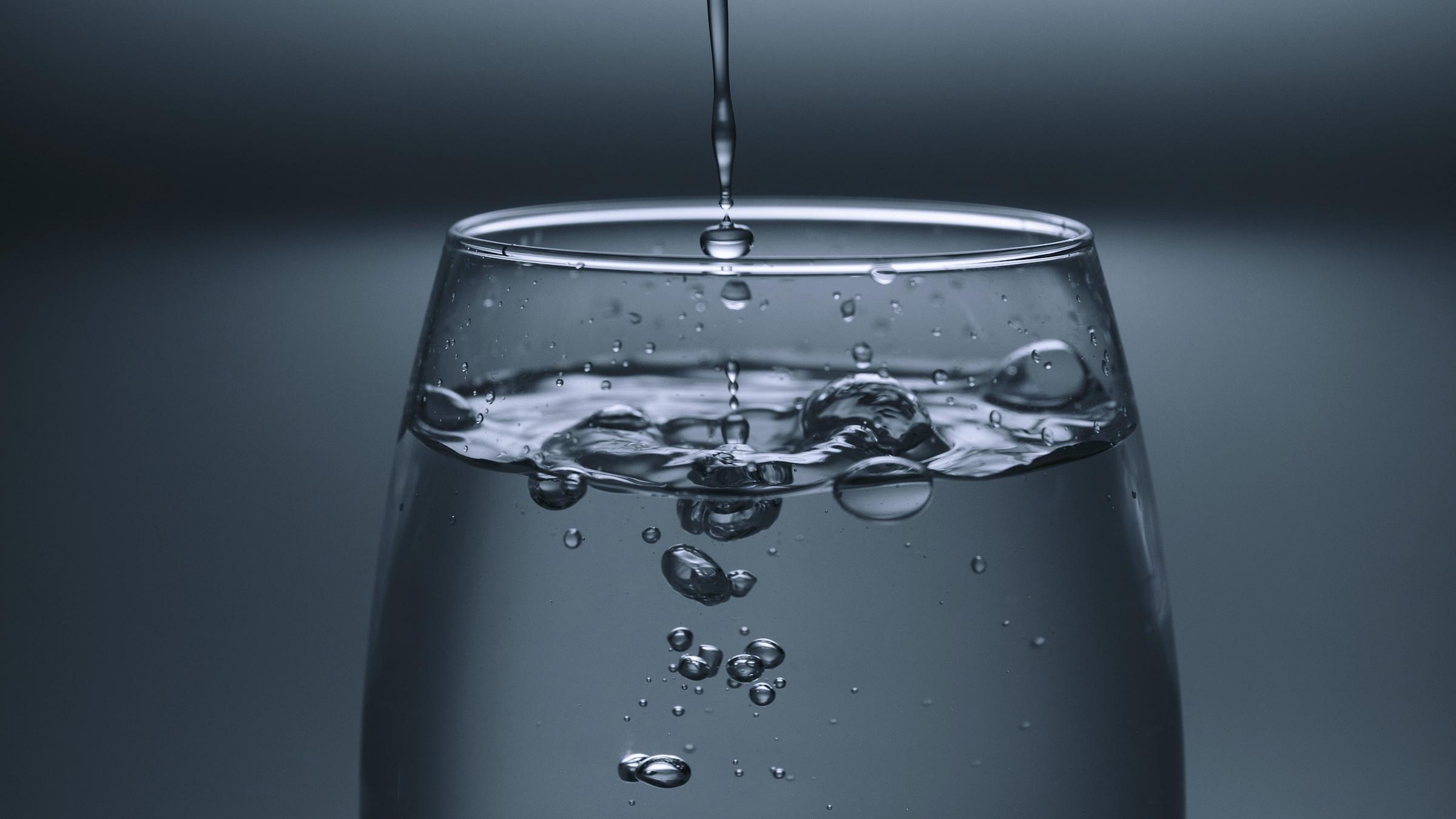 A glass of water being filled up.