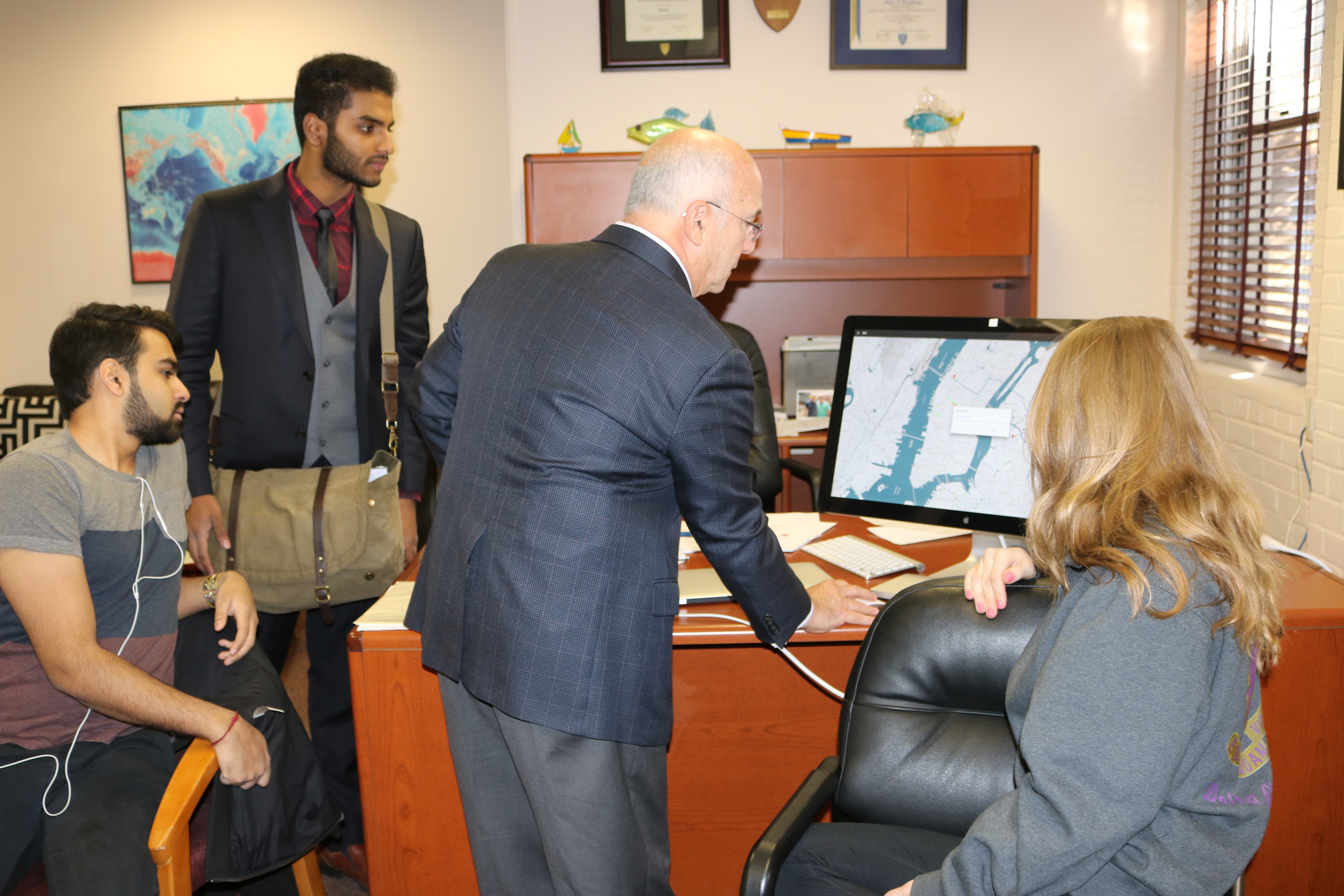 Professor Alan Blumberg advises Karan Shah, Nishanth Meni and Kelly Klewicki on how to fine-tune the Environet app