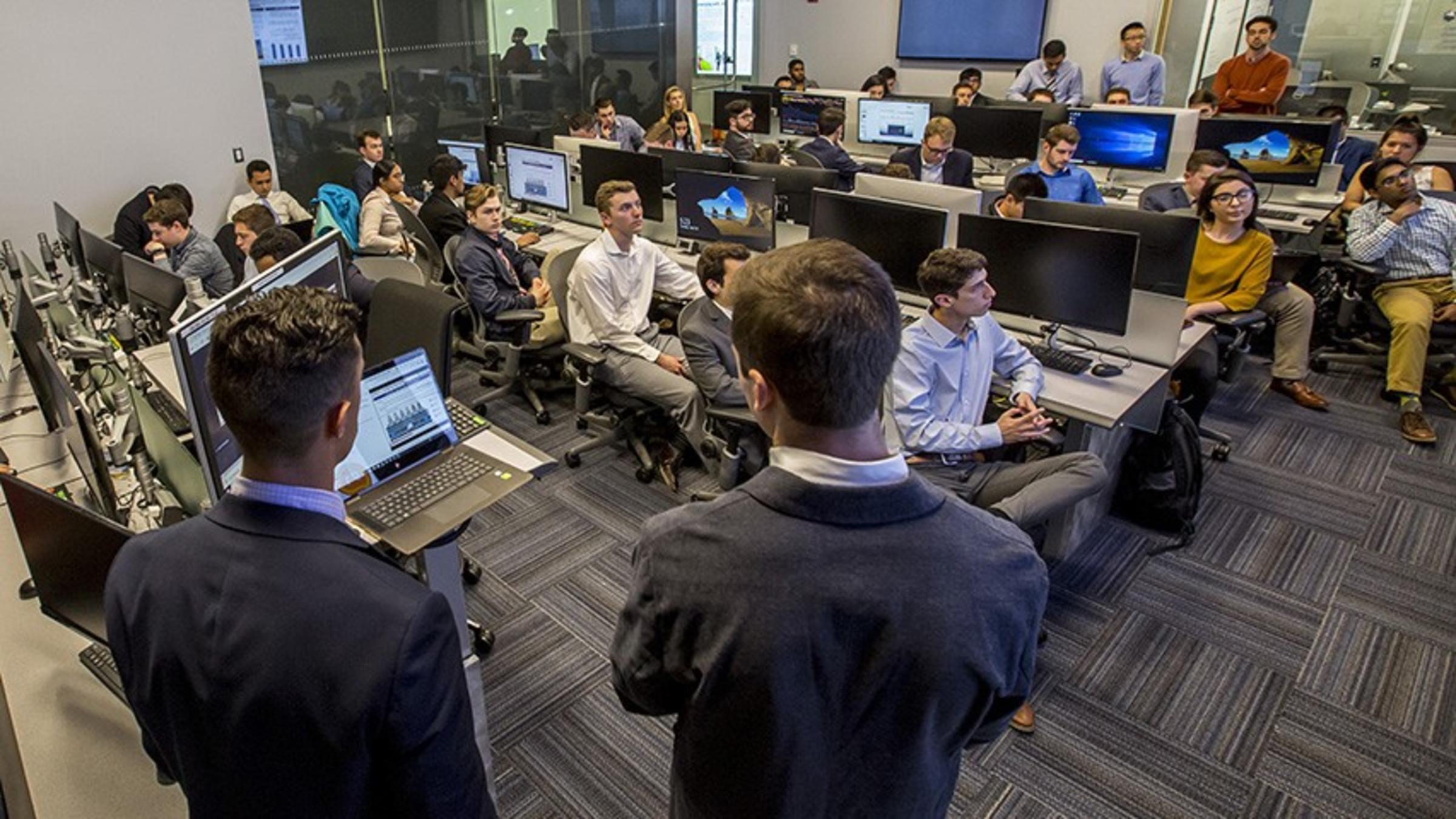 Students in the Hanlon Financial Lab listen to a stock pitch.