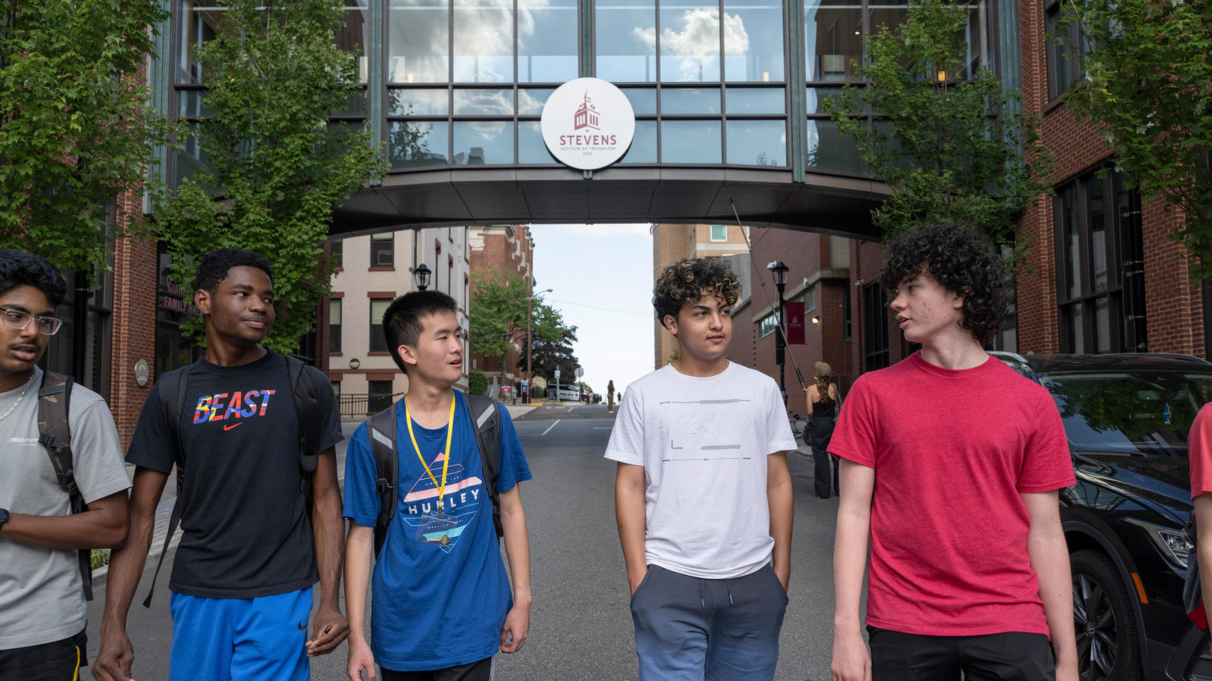 Five high school students walk and talk on Stevens' campus.
