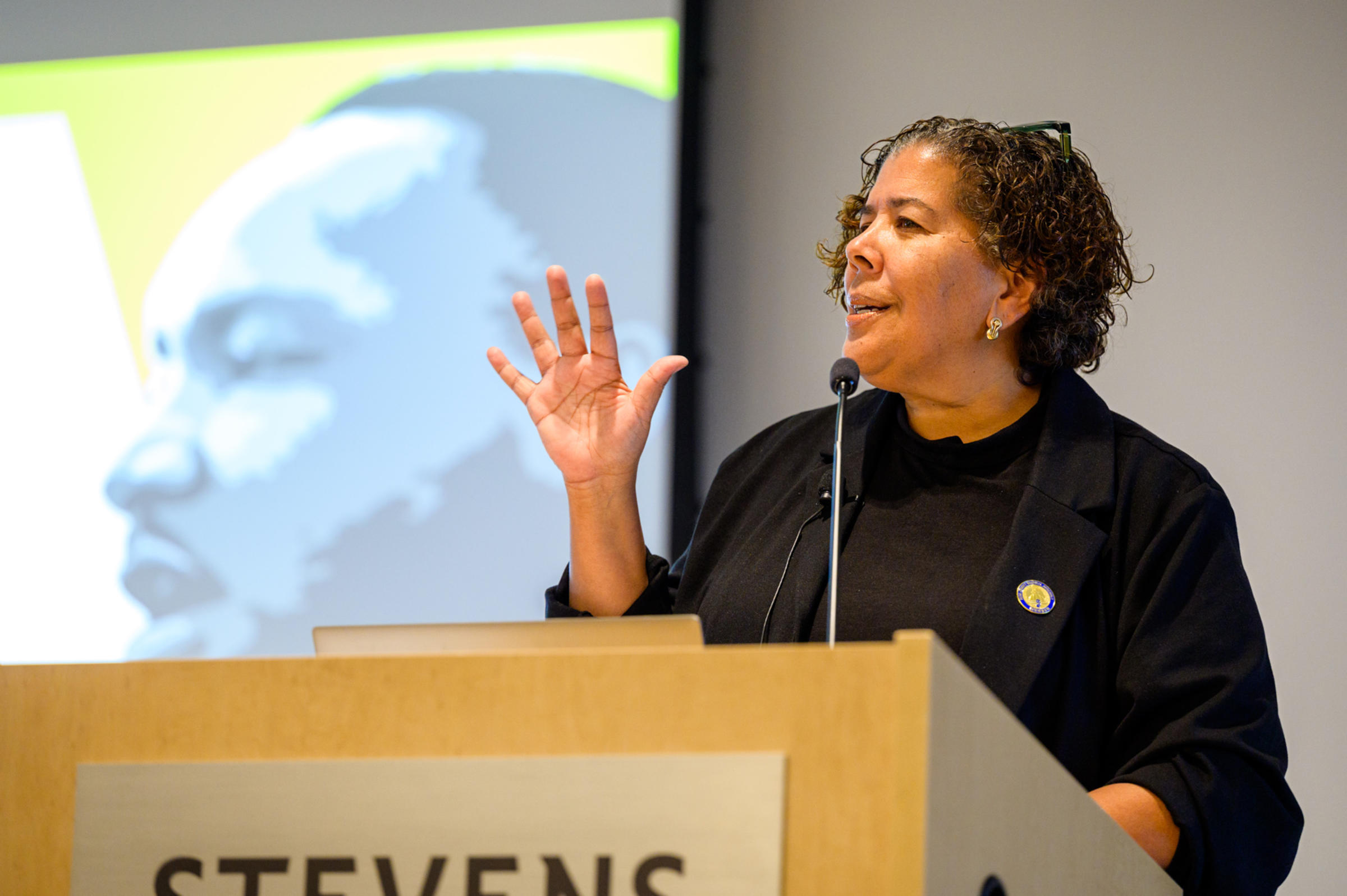 A person speaking into a microphone at a podium.