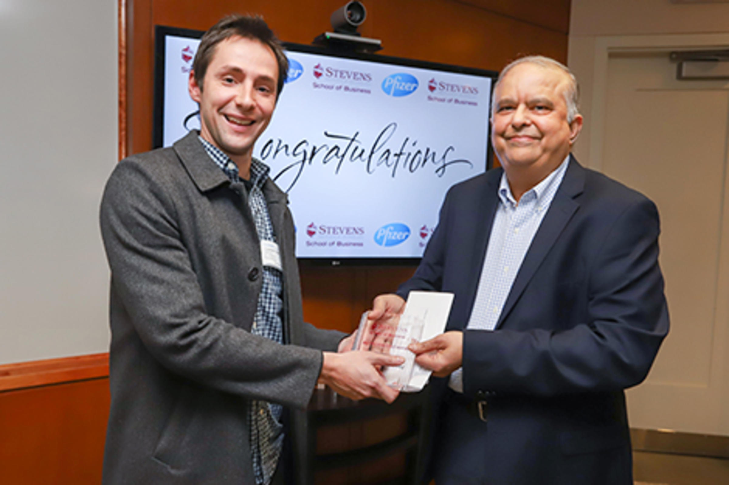 Two men at the podium handing off an award.