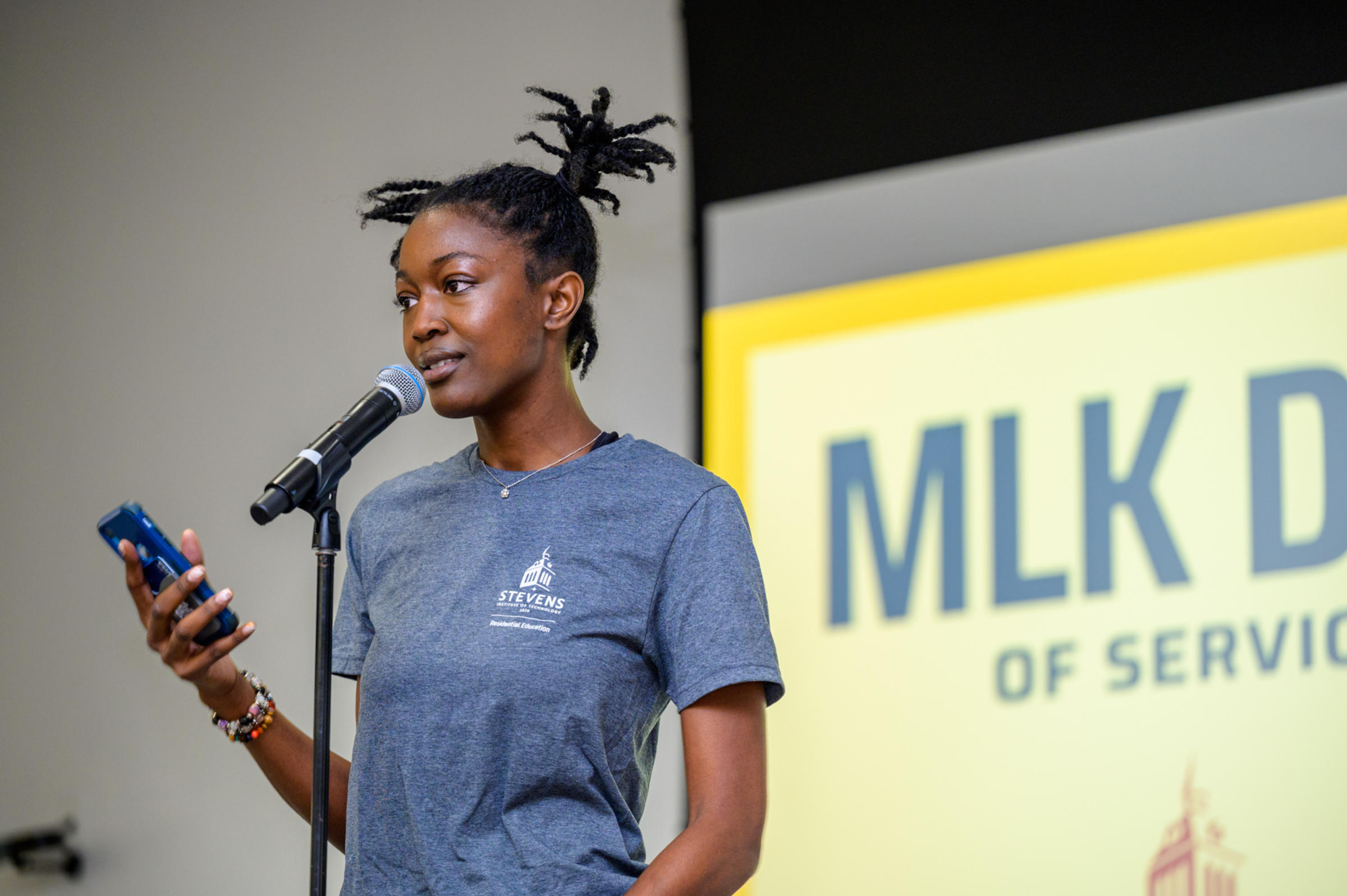 Photo of a person holding a microphone and speaking.