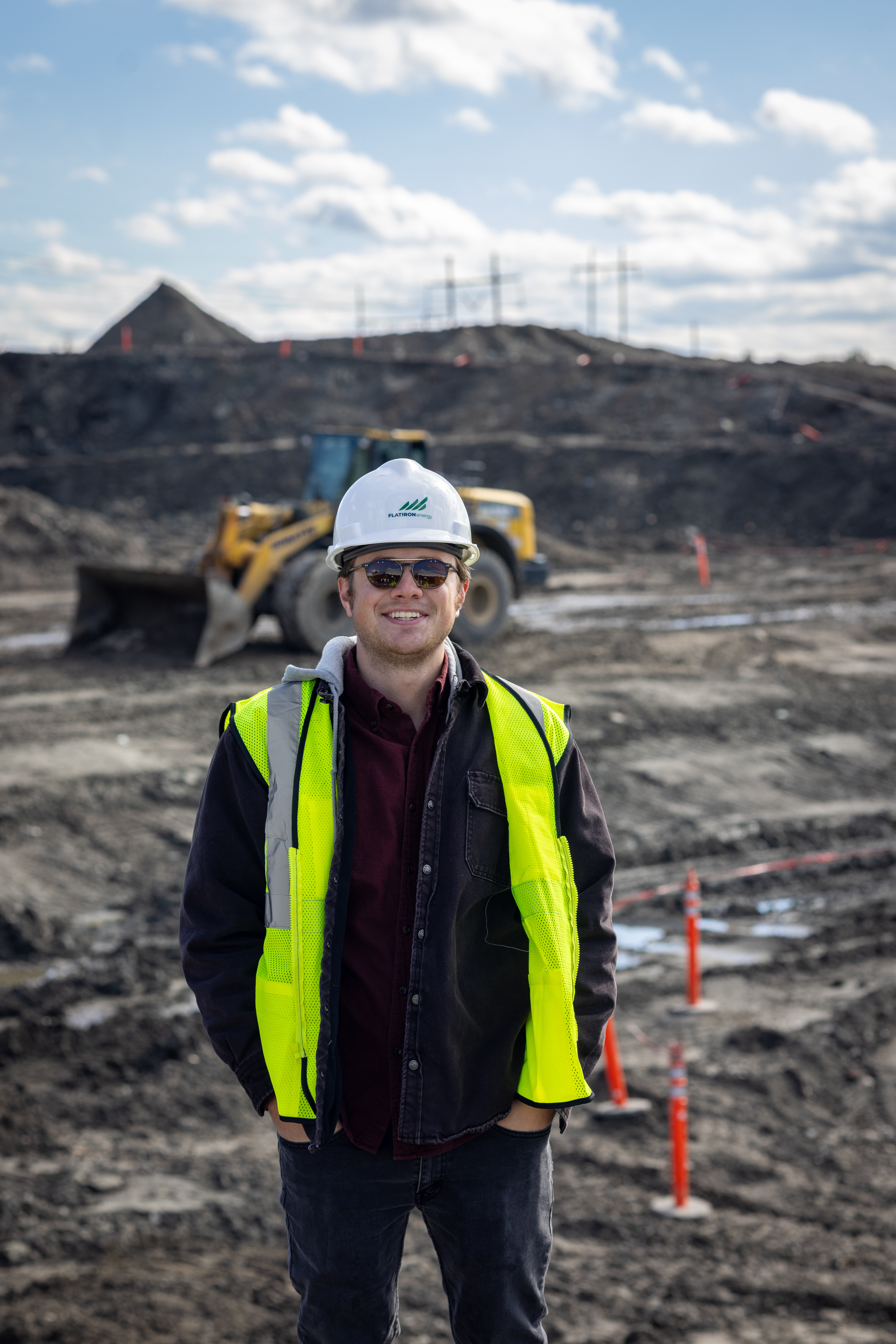 William Kraemer stands at a work site with a hard hat and vest on