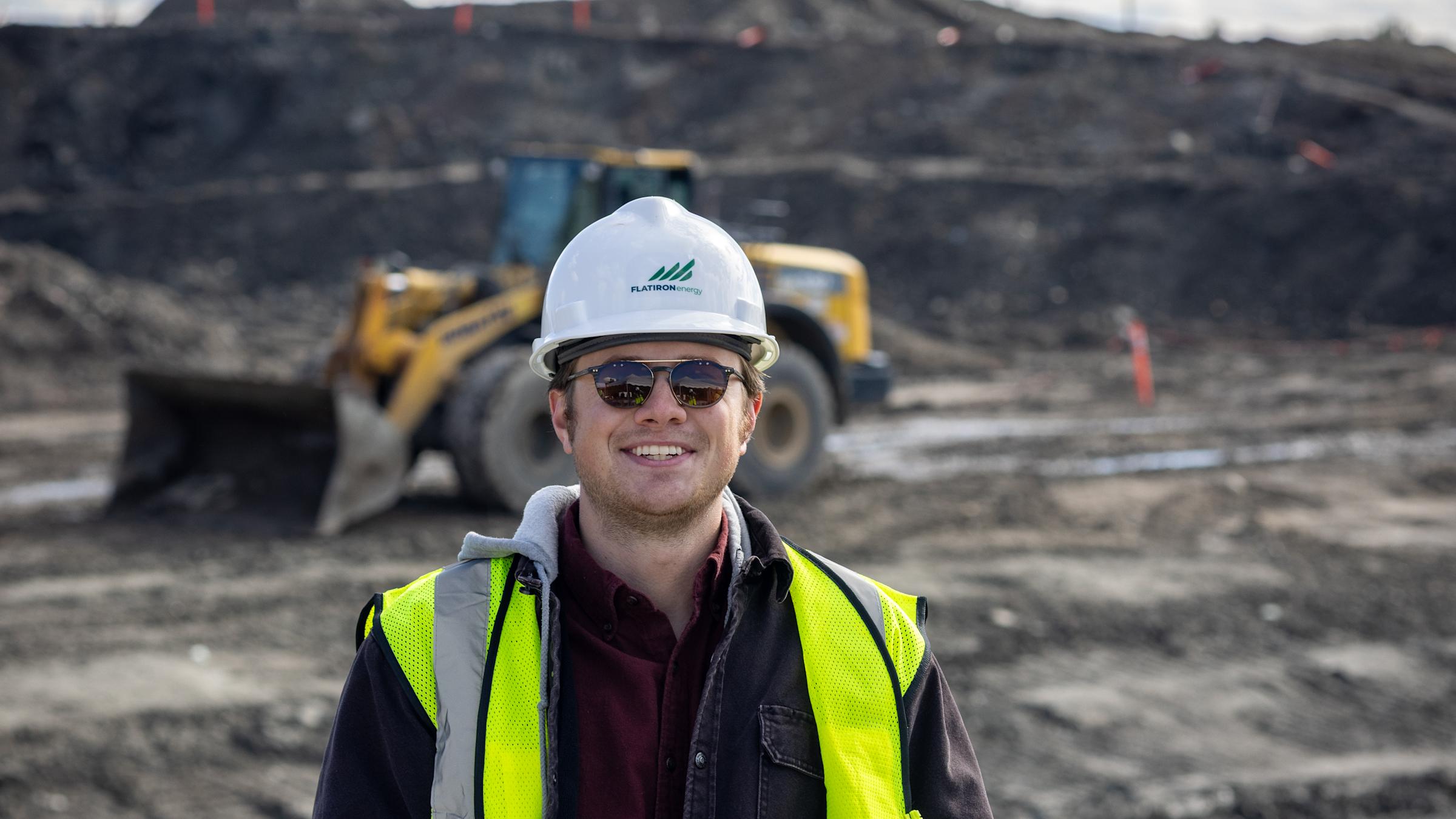 William Kraemer stands at a work site with a hard hat and vest on