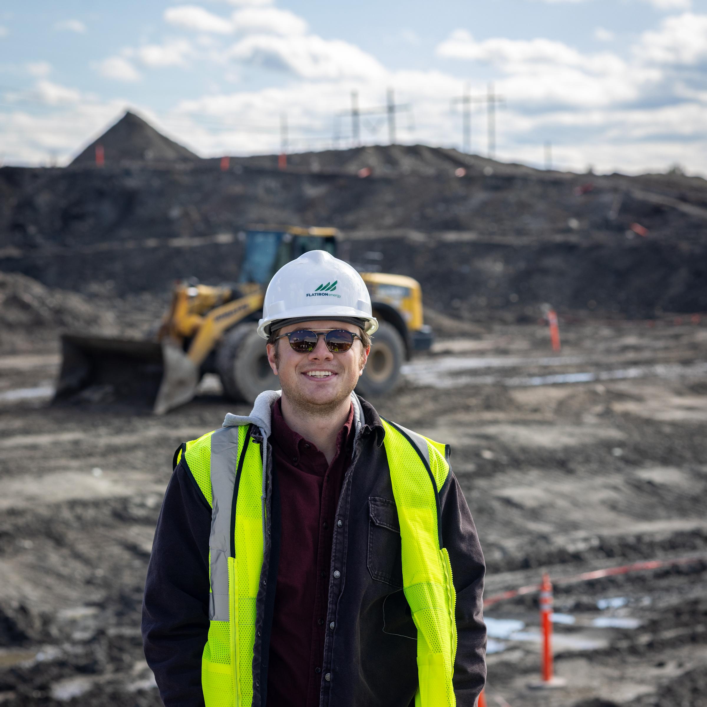 William Kraemer stands at a work site with a hard hat and vest on