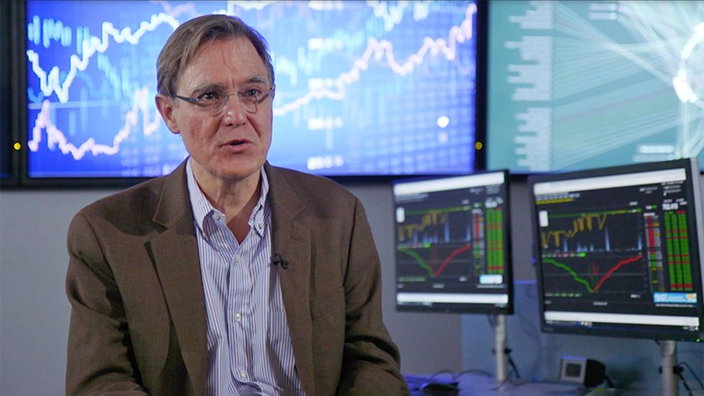 Dr. Jeffrey Nickerson sitting in front of several screens showing different data visualization graphs.