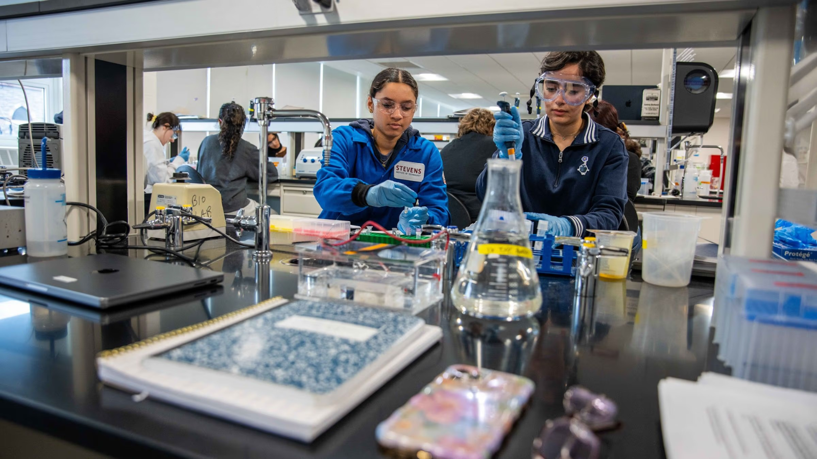 Two students wearing personal protective gear working in the newly renovated chemical biology laboratory..