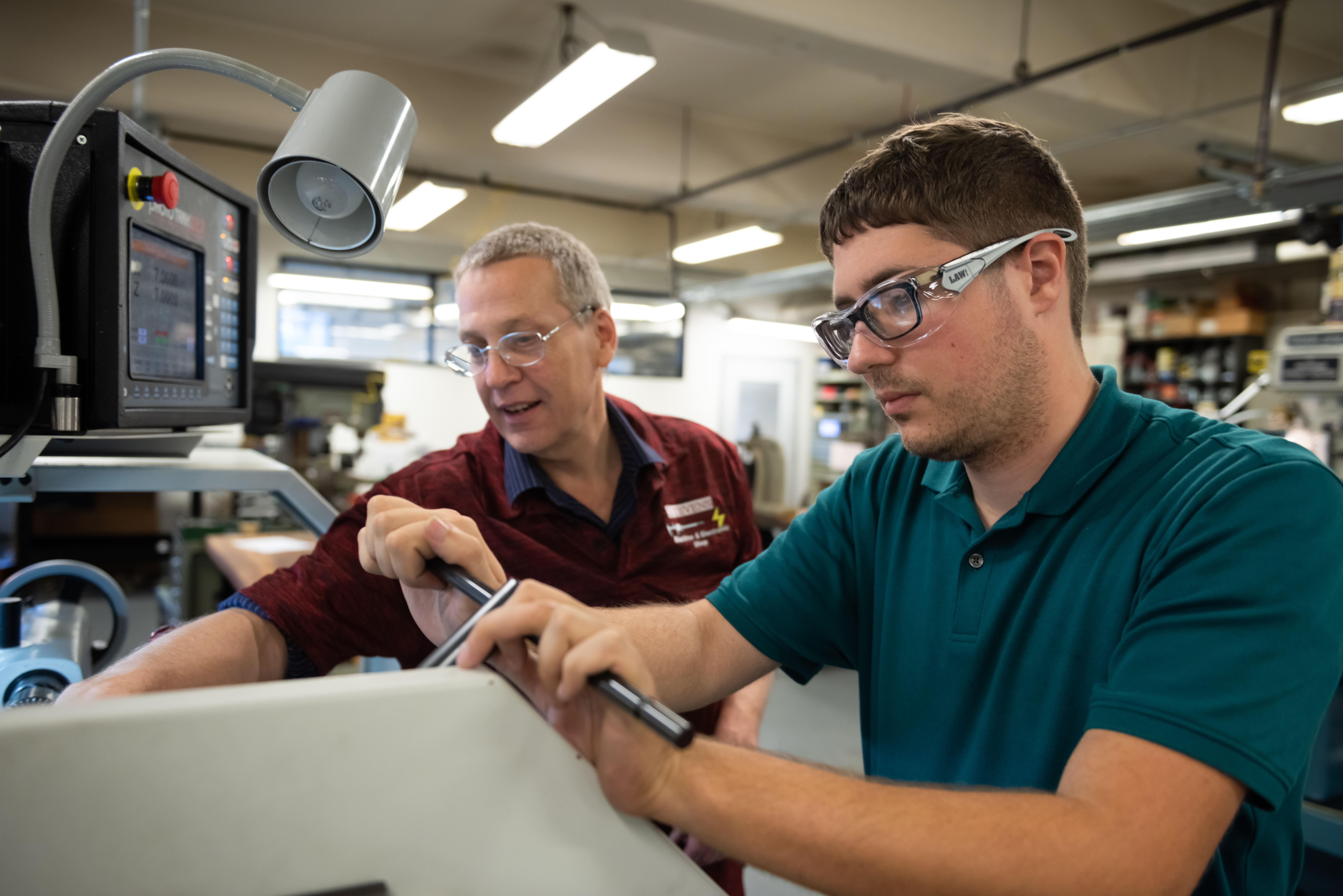 A student and professor working on building a prototype