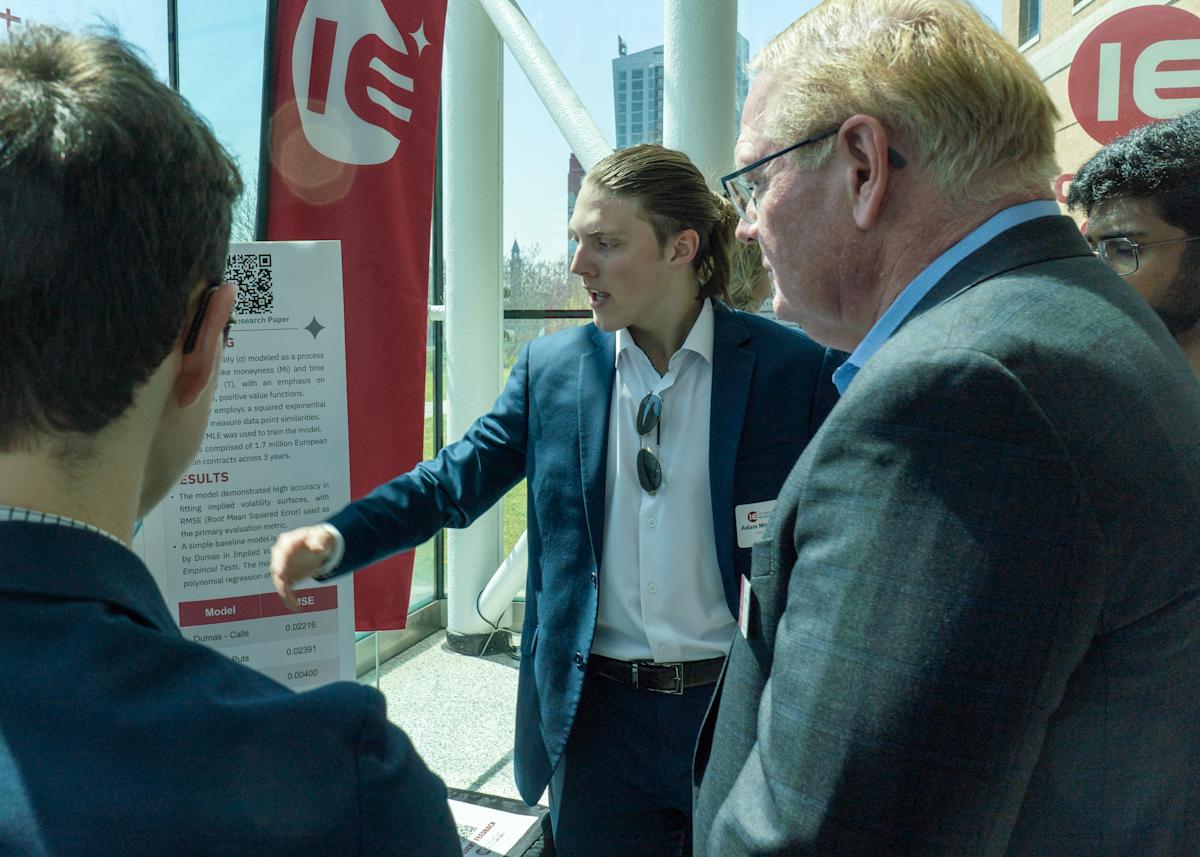 Jeff Hedrick listens to a student give a presentation at the Innovation Expo