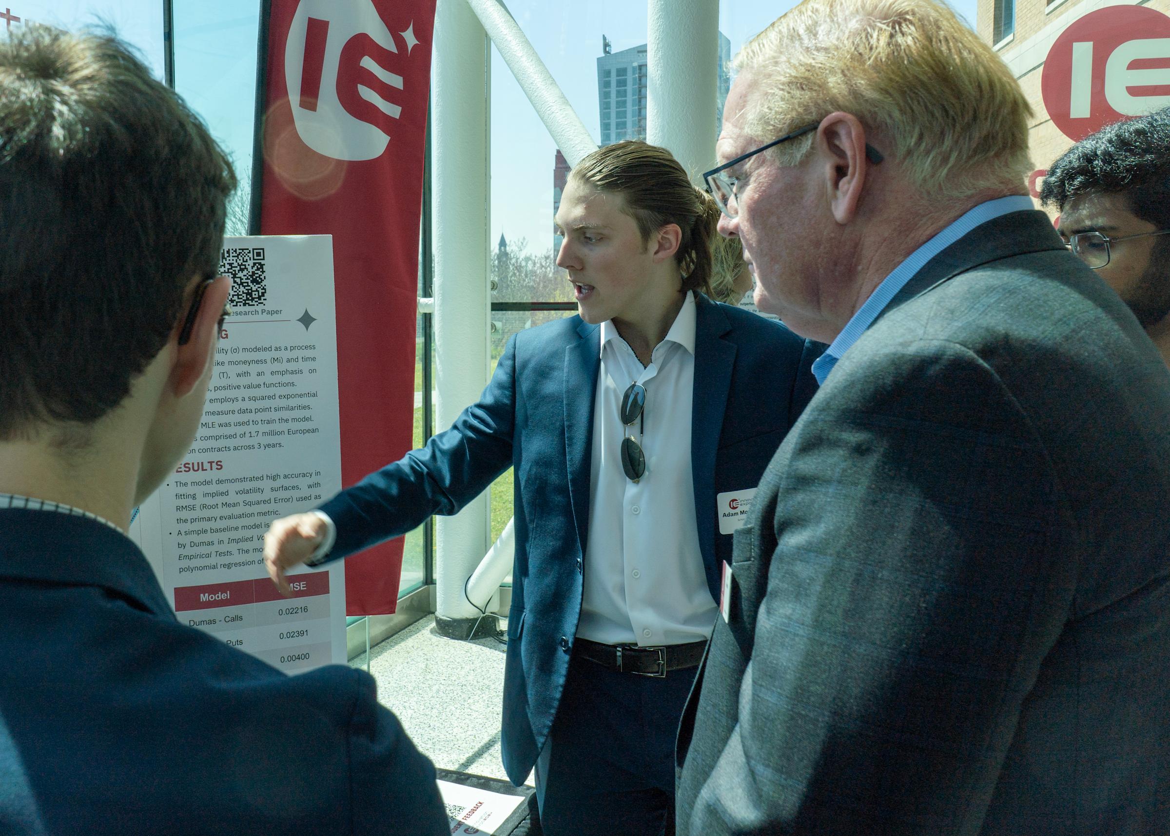 Jeff Hedrick listens to a student give a presentation at the Innovation Expo