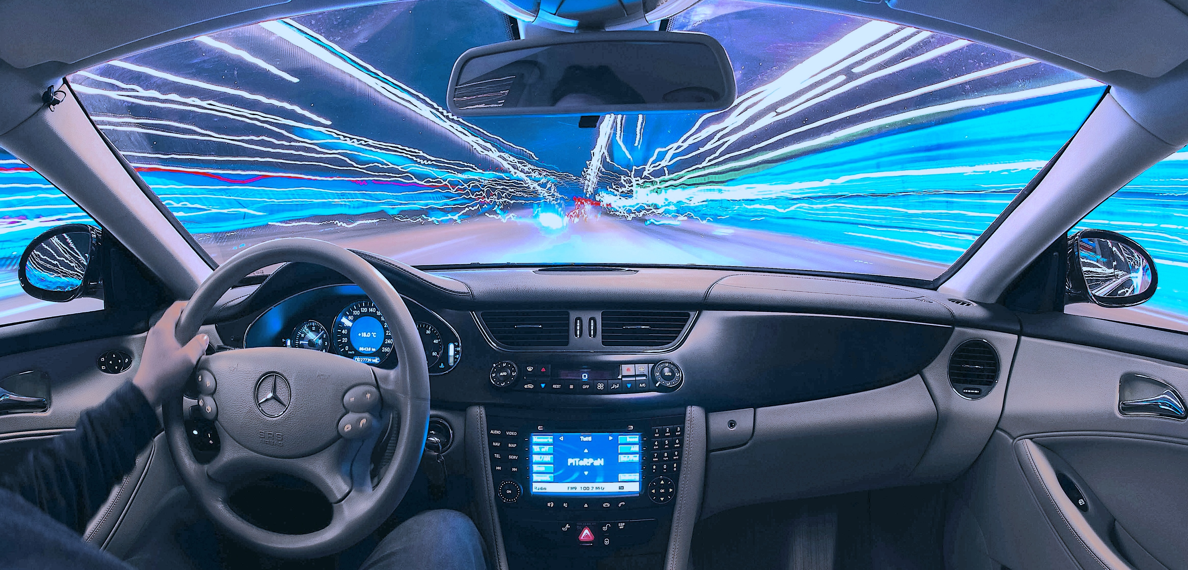 Time-lapse highway seen through front windshield of a moving car