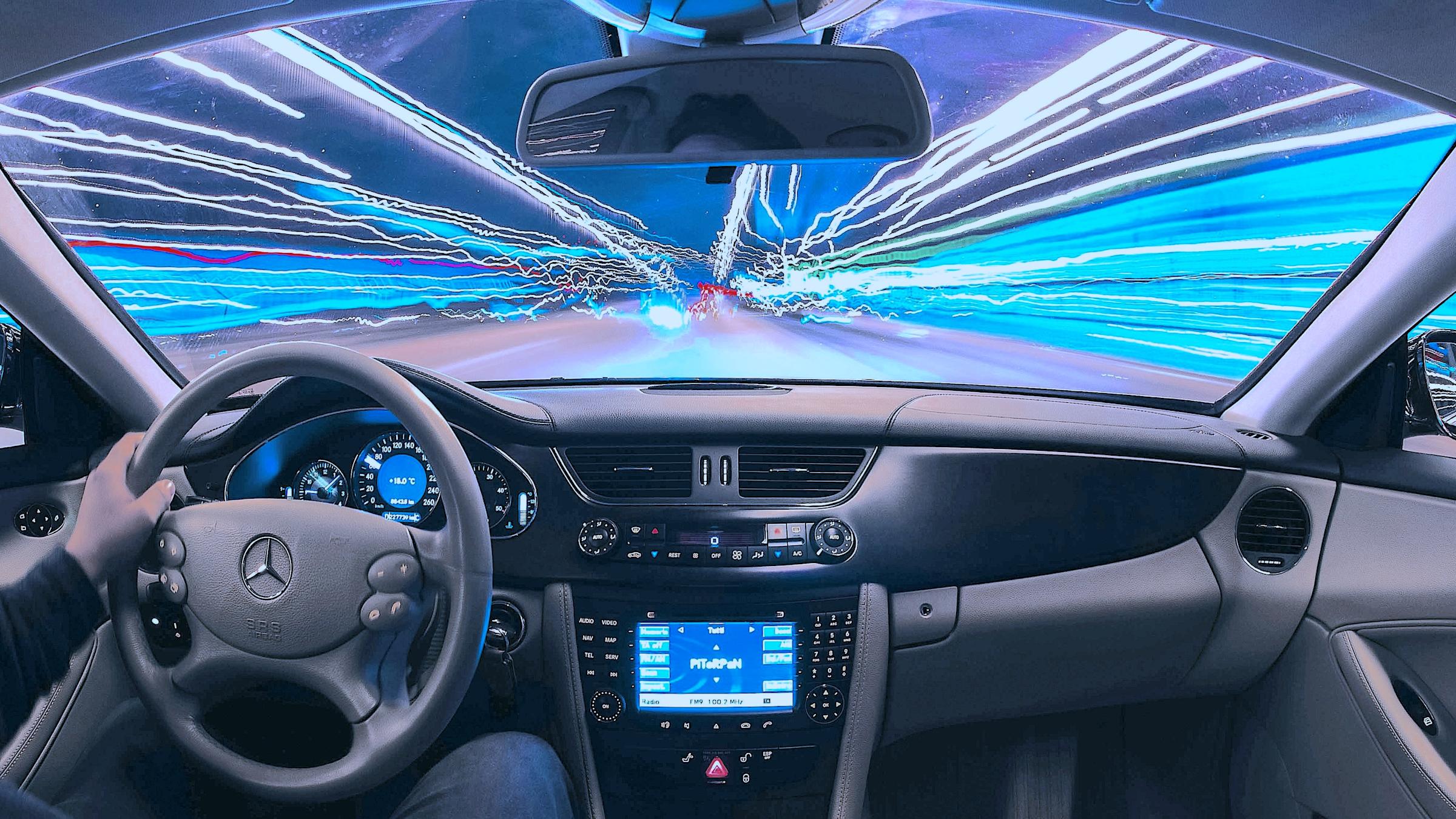 Time-lapse highway seen through front windshield of a moving car