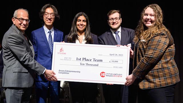 Winning team at Stevens pitch competition accepting oversized $10,000 check from President Nariman Farvardin