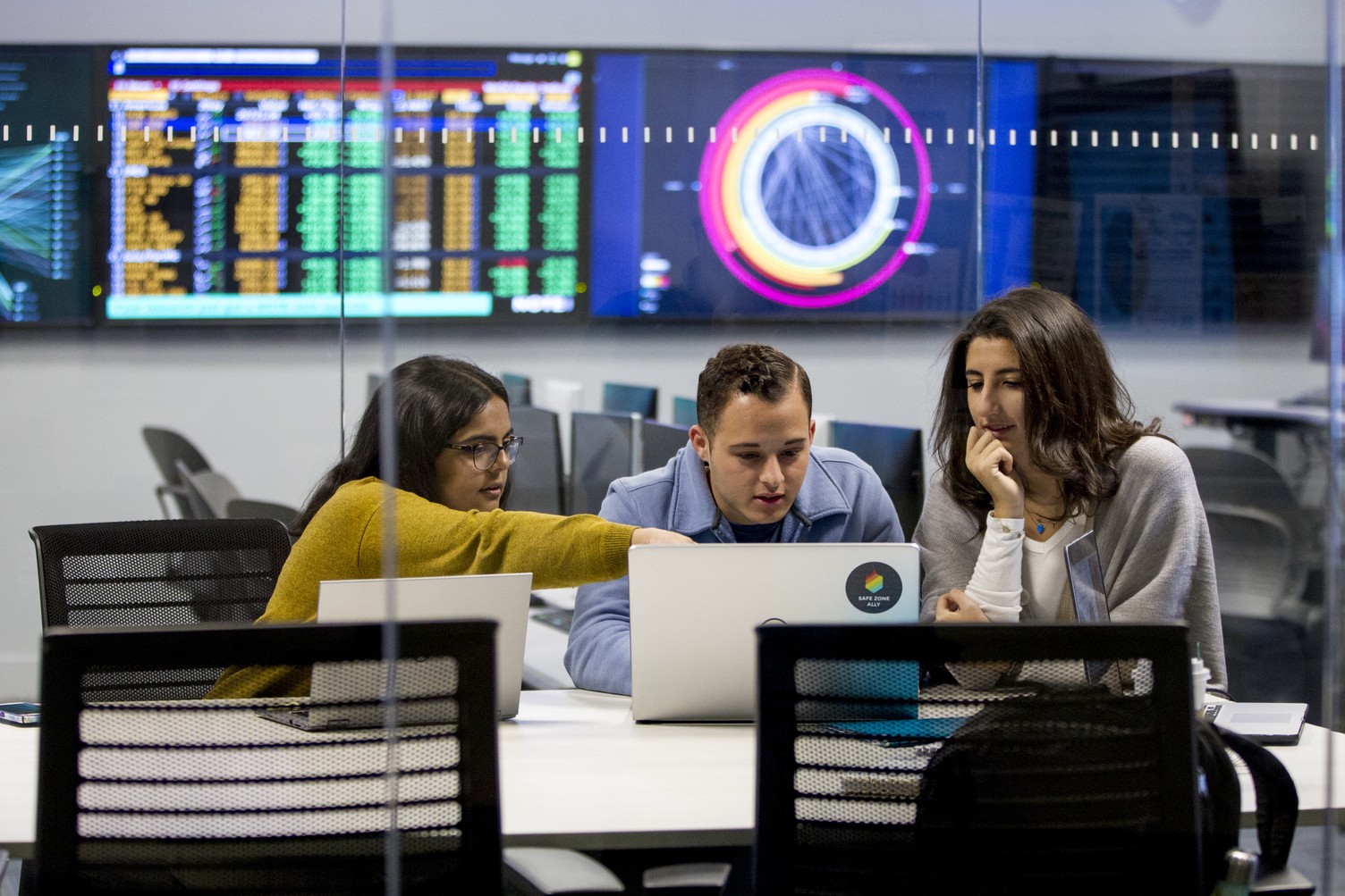 Students and Professor collaborate over laptop