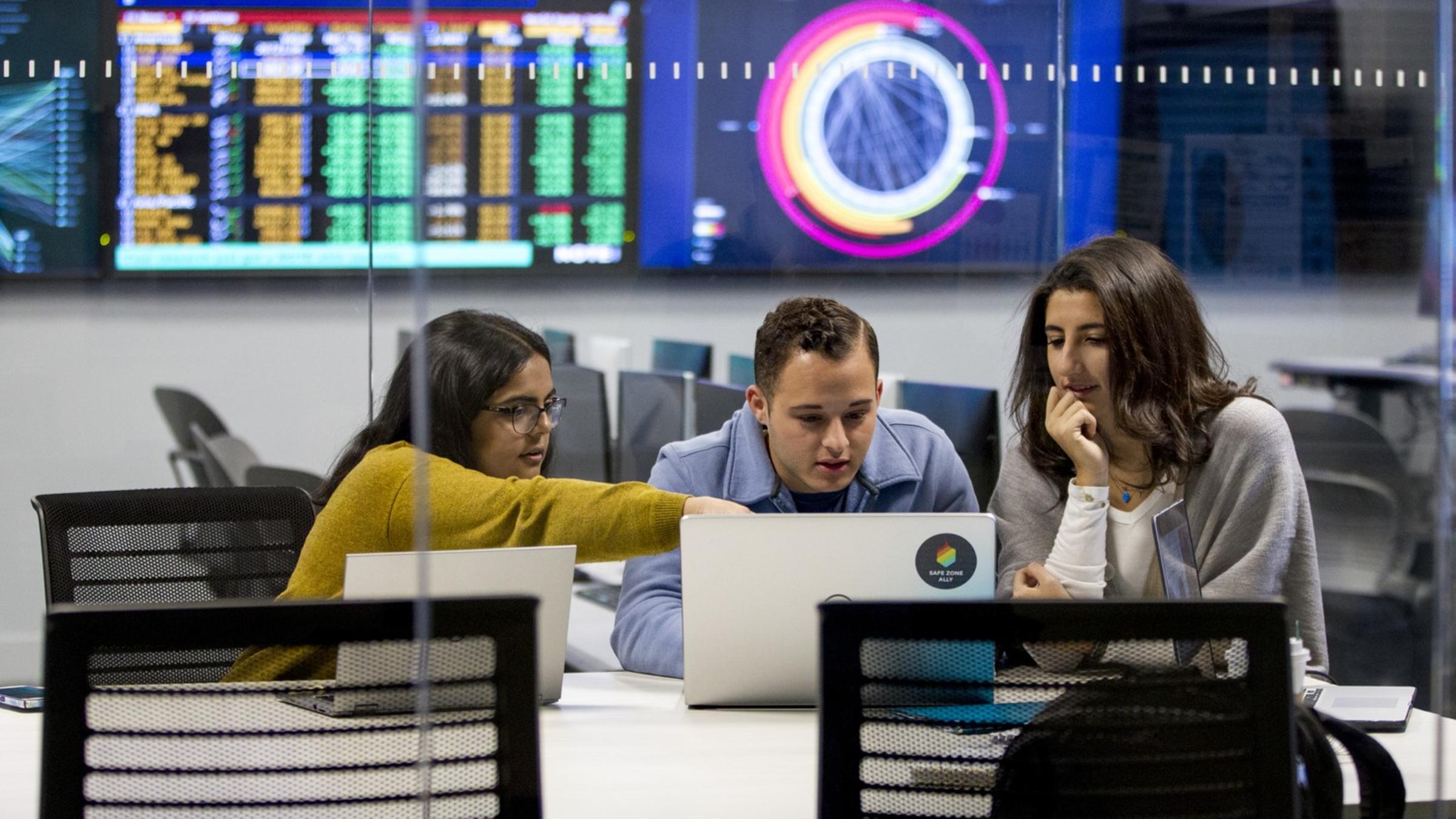 Students and Professor collaborate over laptop