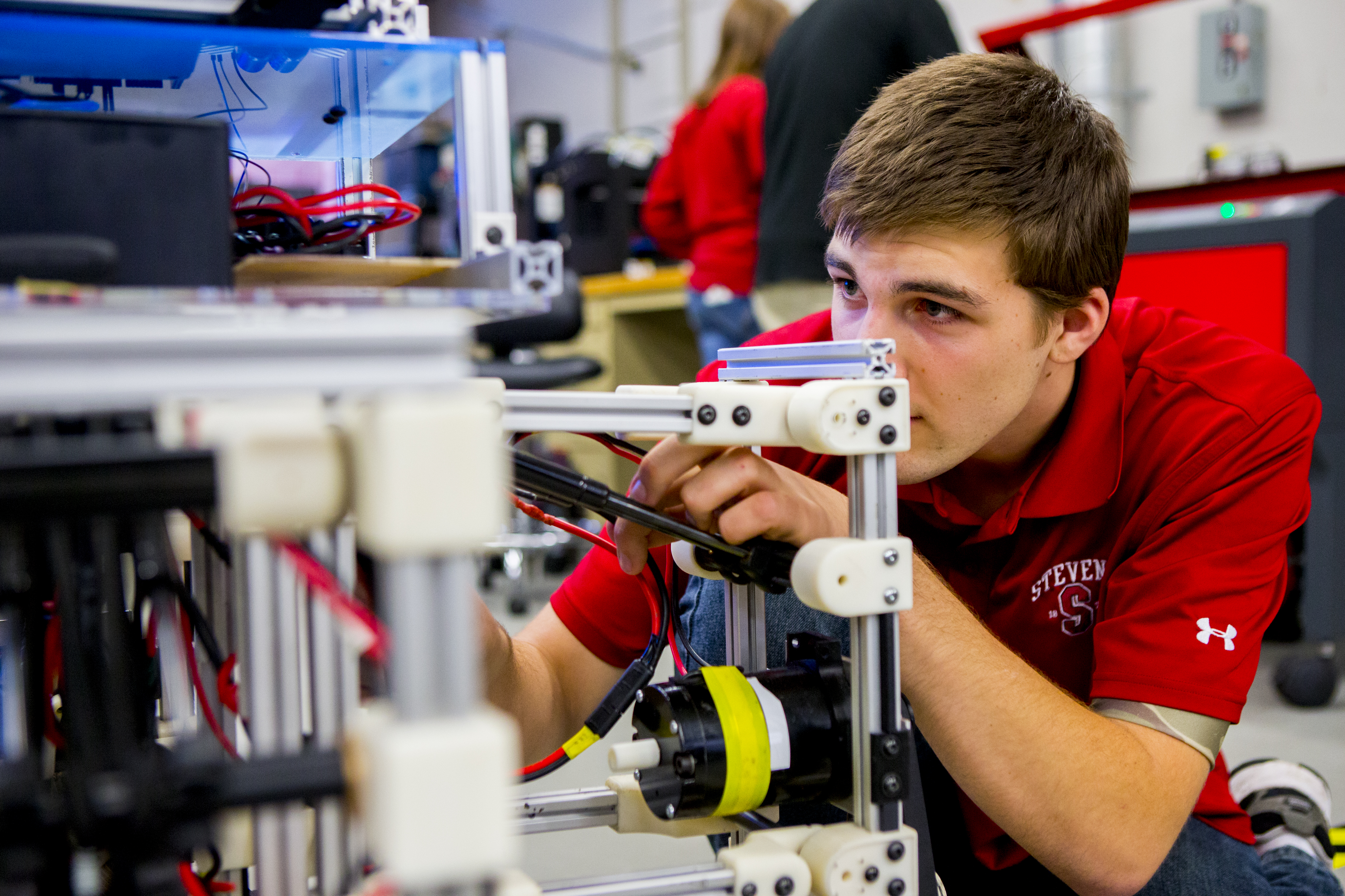 student assessing robot in lab