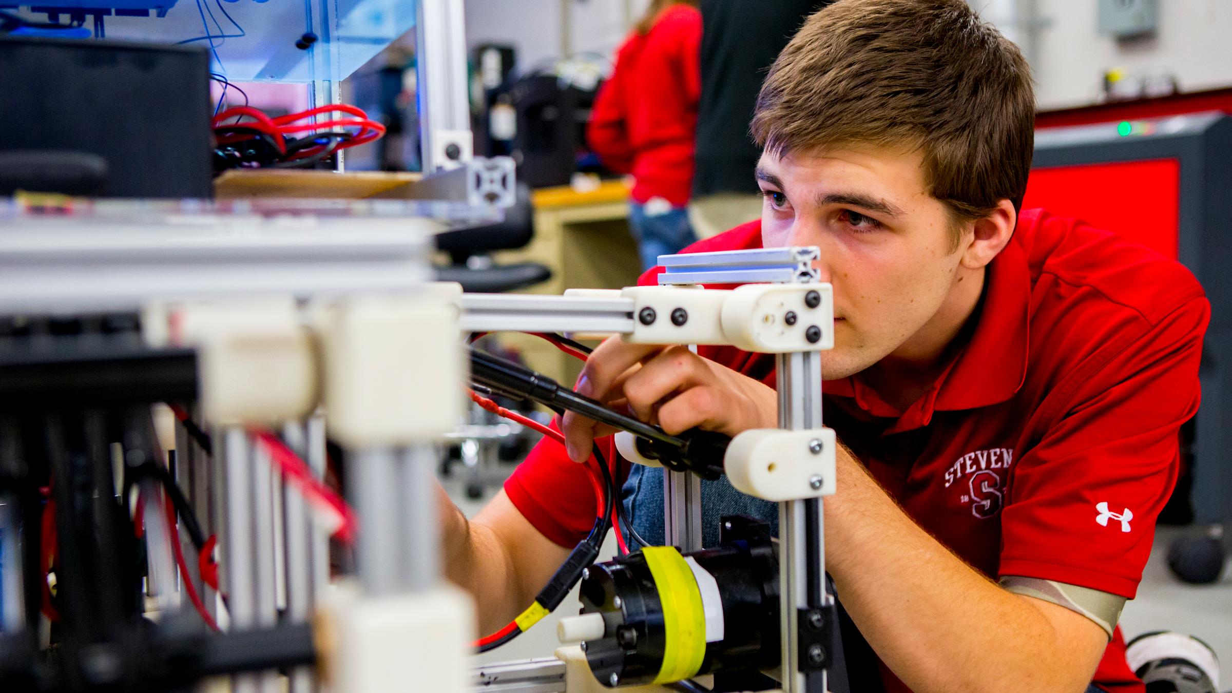 student assessing robot in lab