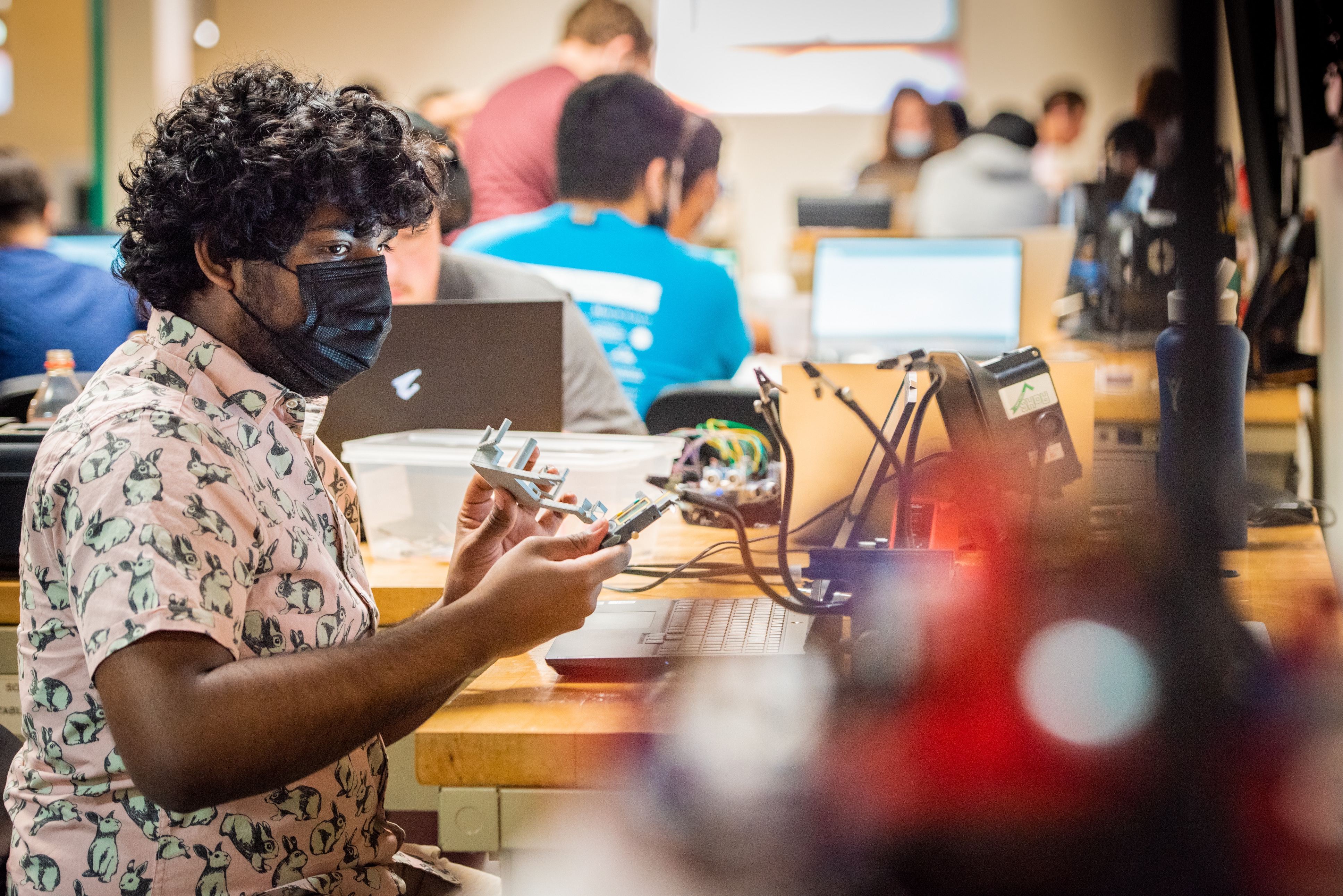 Student working on a project in a lab with his computer on his desk