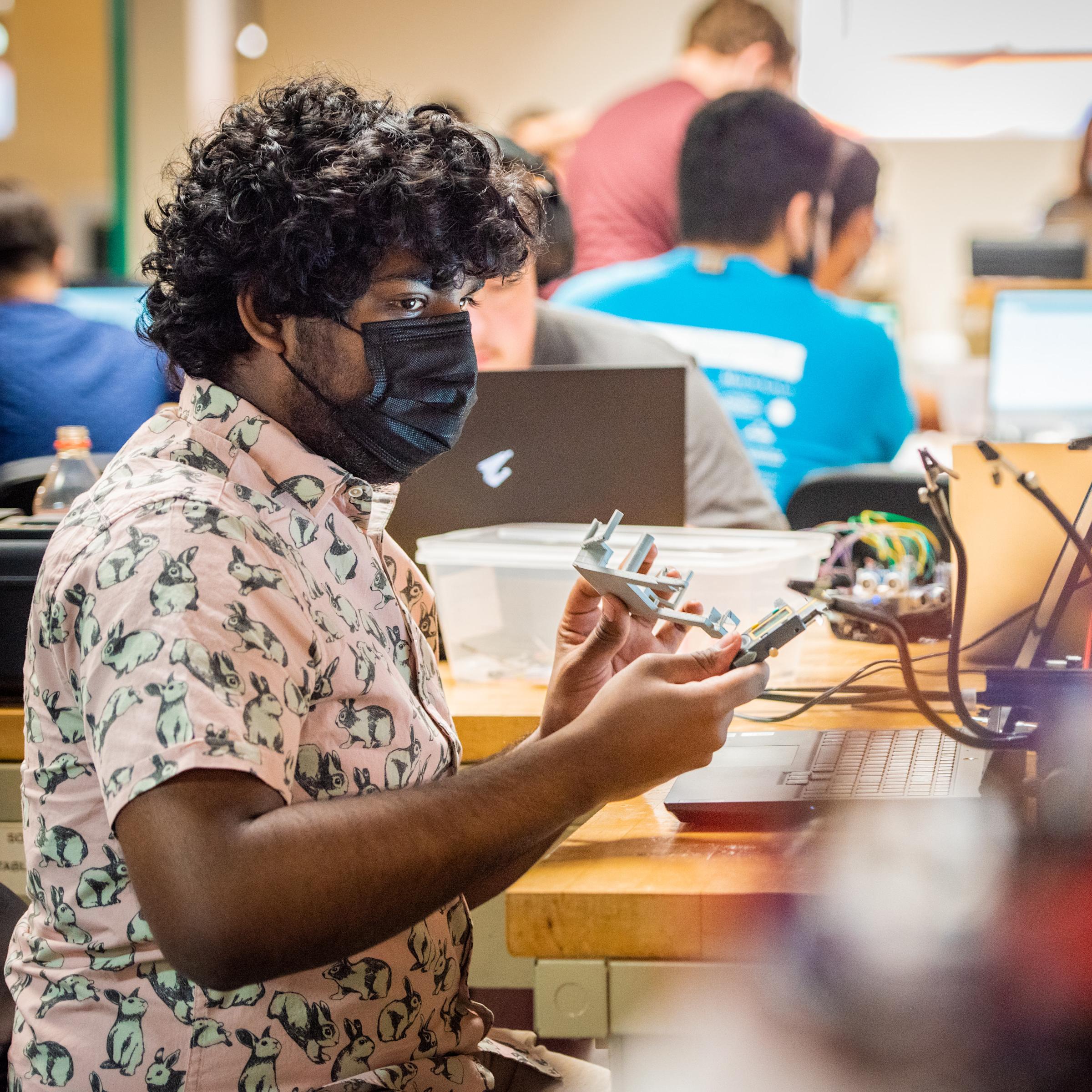 Student working on a project in a lab with his computer on his desk