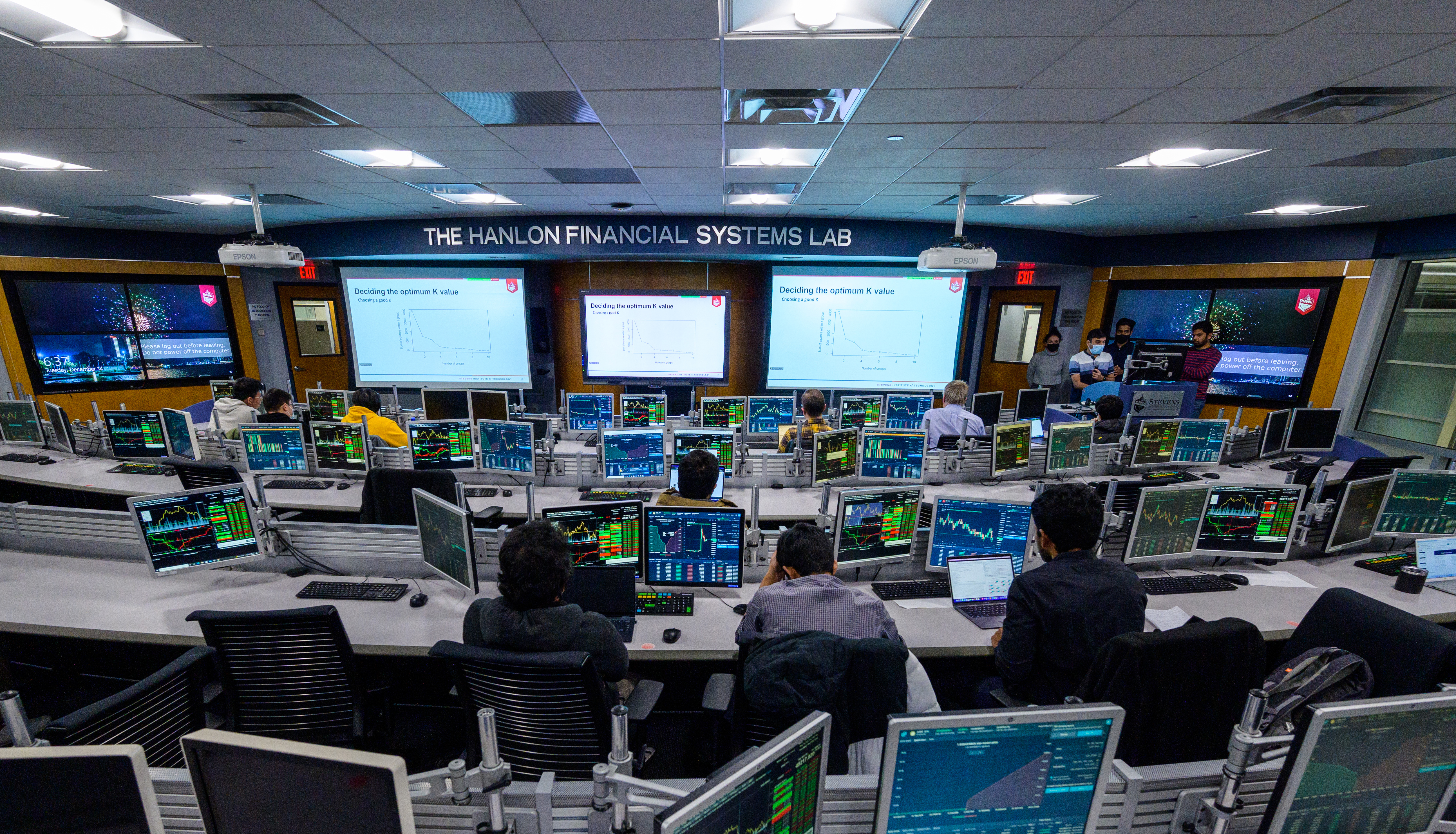 Students give presentation in Hanlon lab with many computer monitors.
