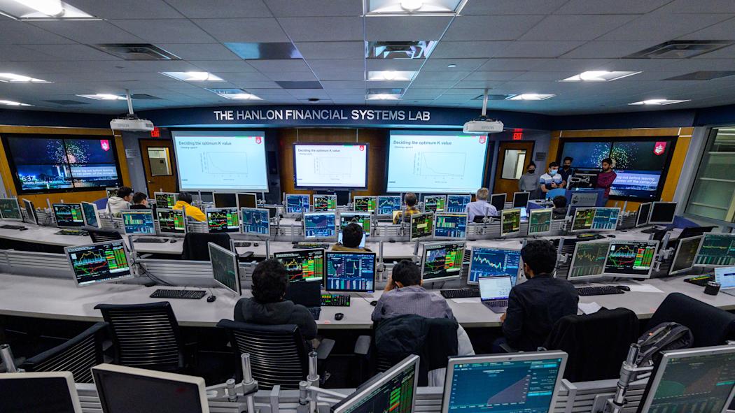 Students give presentation in Hanlon lab with many computer monitors.