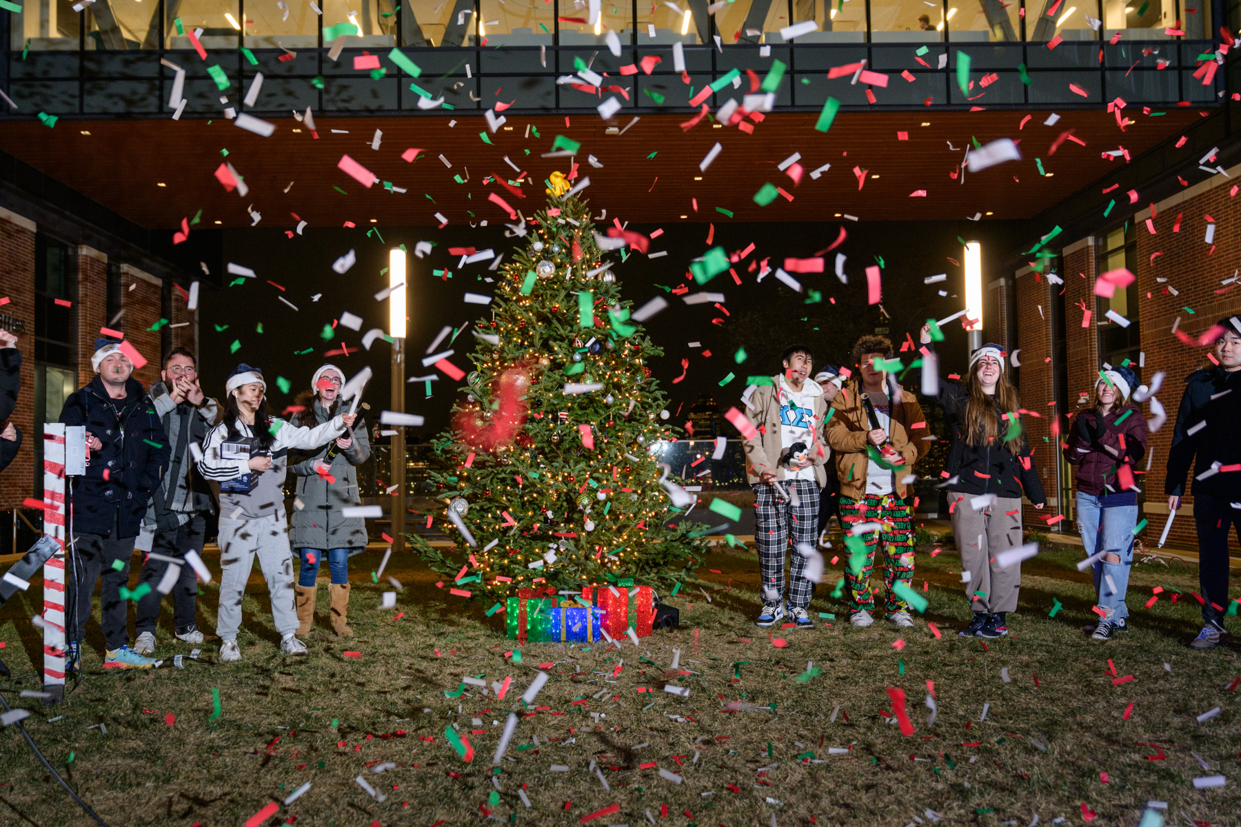 Confetti flies around a Christmas tree.