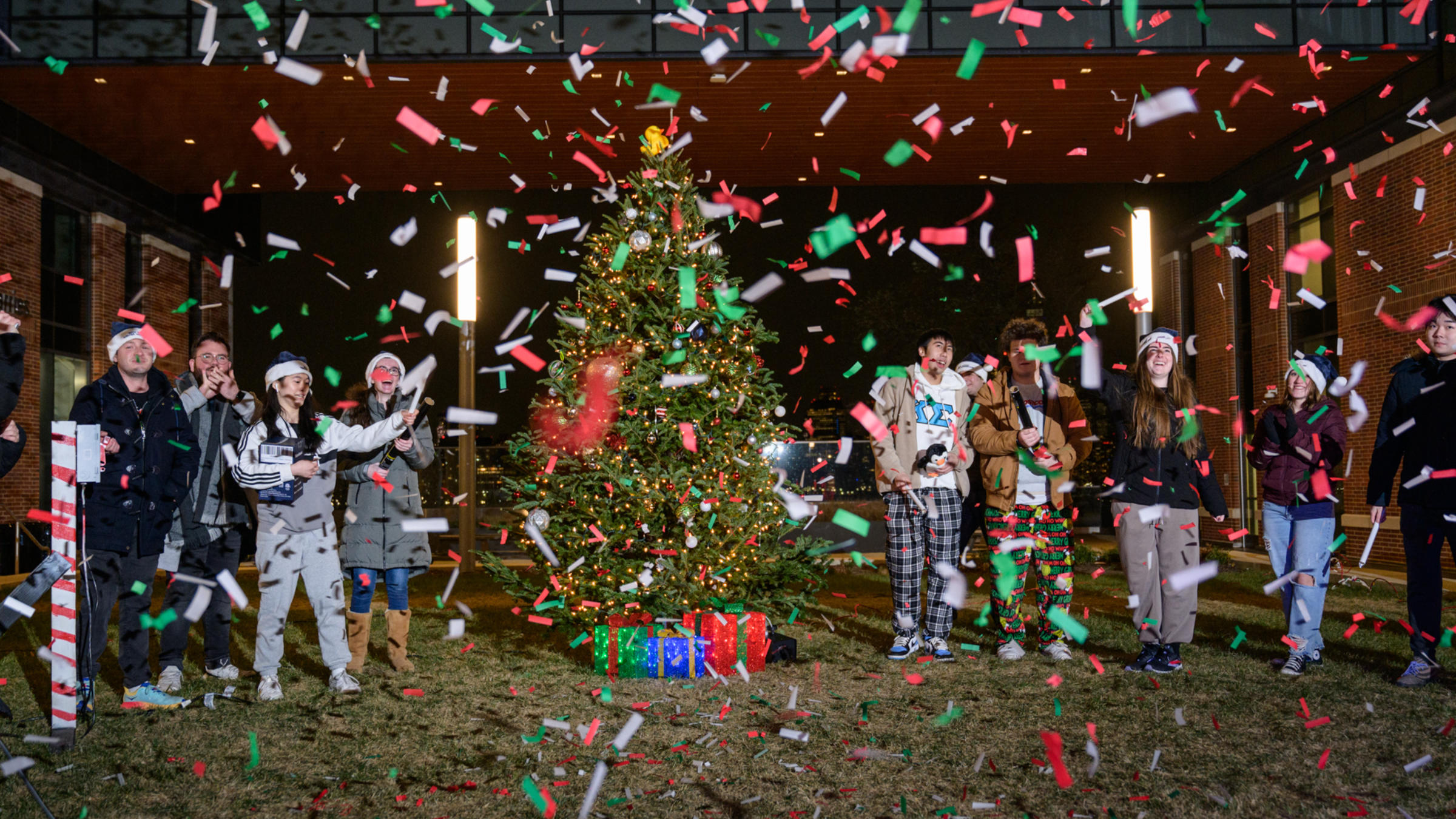 Confetti flies around a Christmas tree.