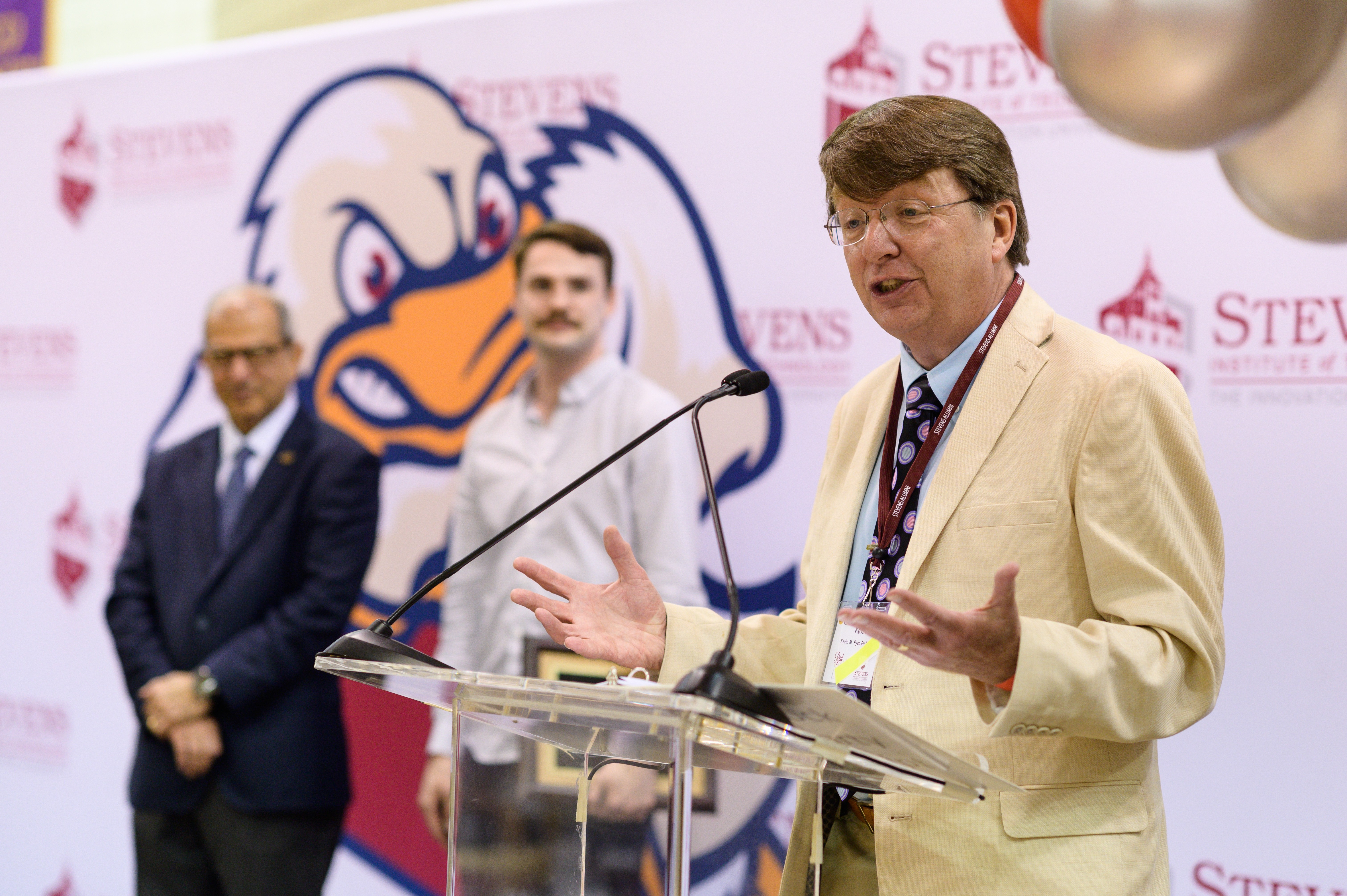 Kevin Ryan speaks at podium with President Nariman Farvardin in the background