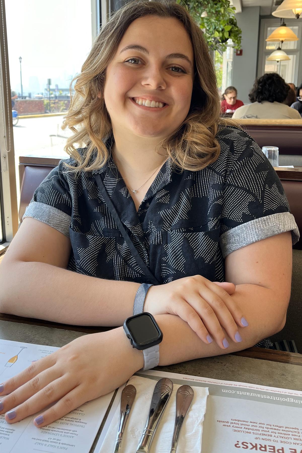 Stevens student Laura Masciola smiling in a booth at a restaurant.