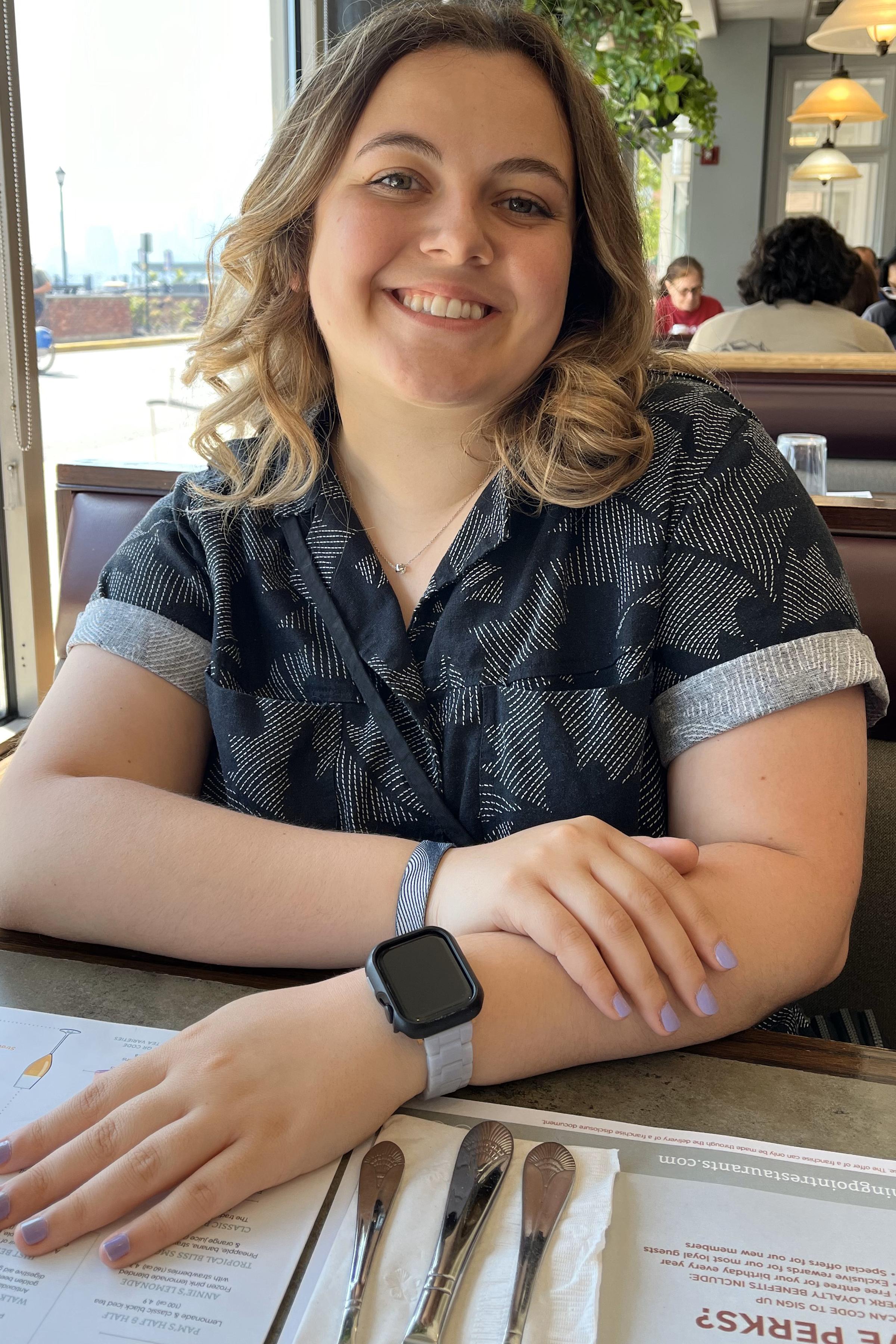 Stevens student Laura Masciola smiling in a booth at a restaurant.