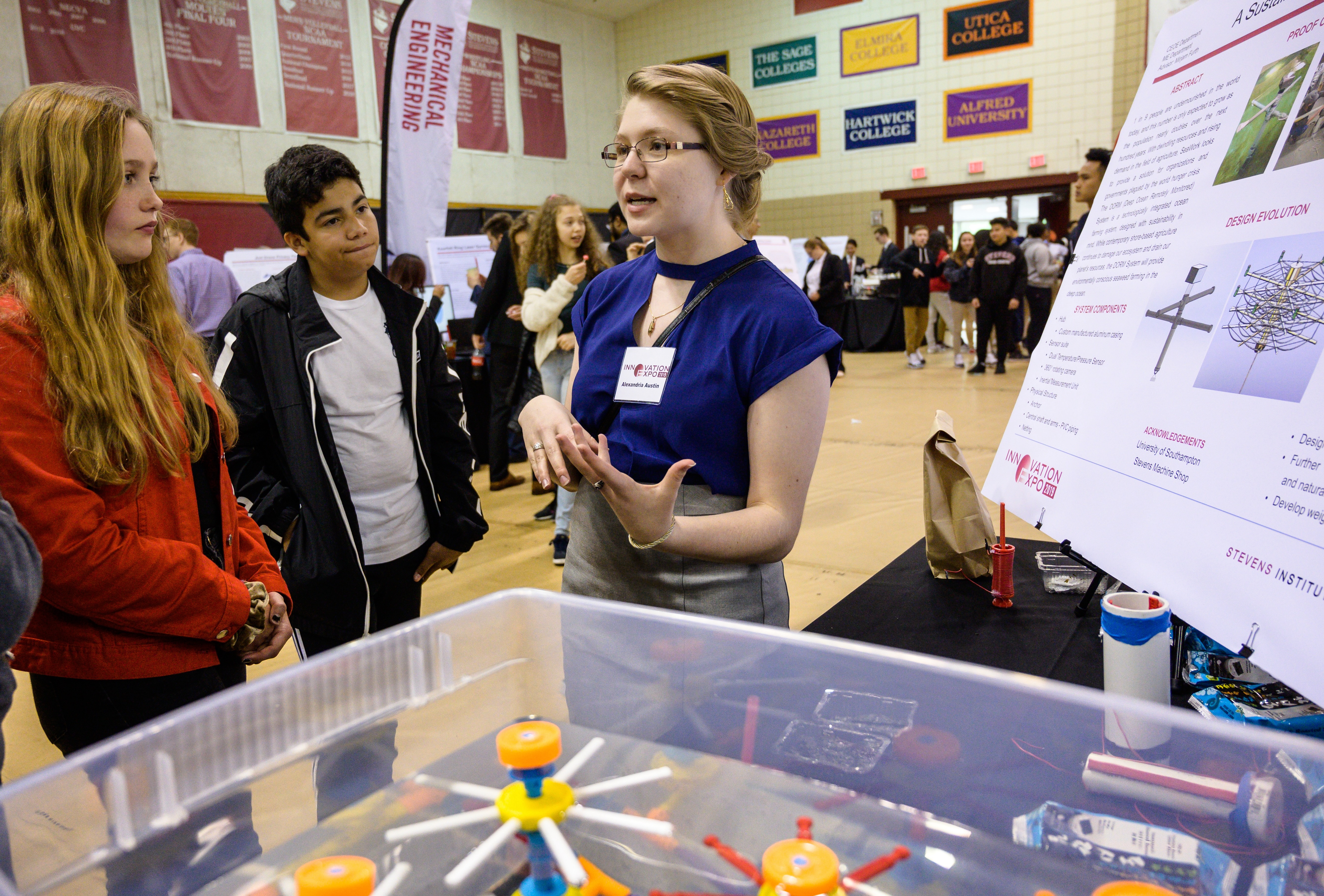 Three female students explaining a project at the Stevens Innovation Expo