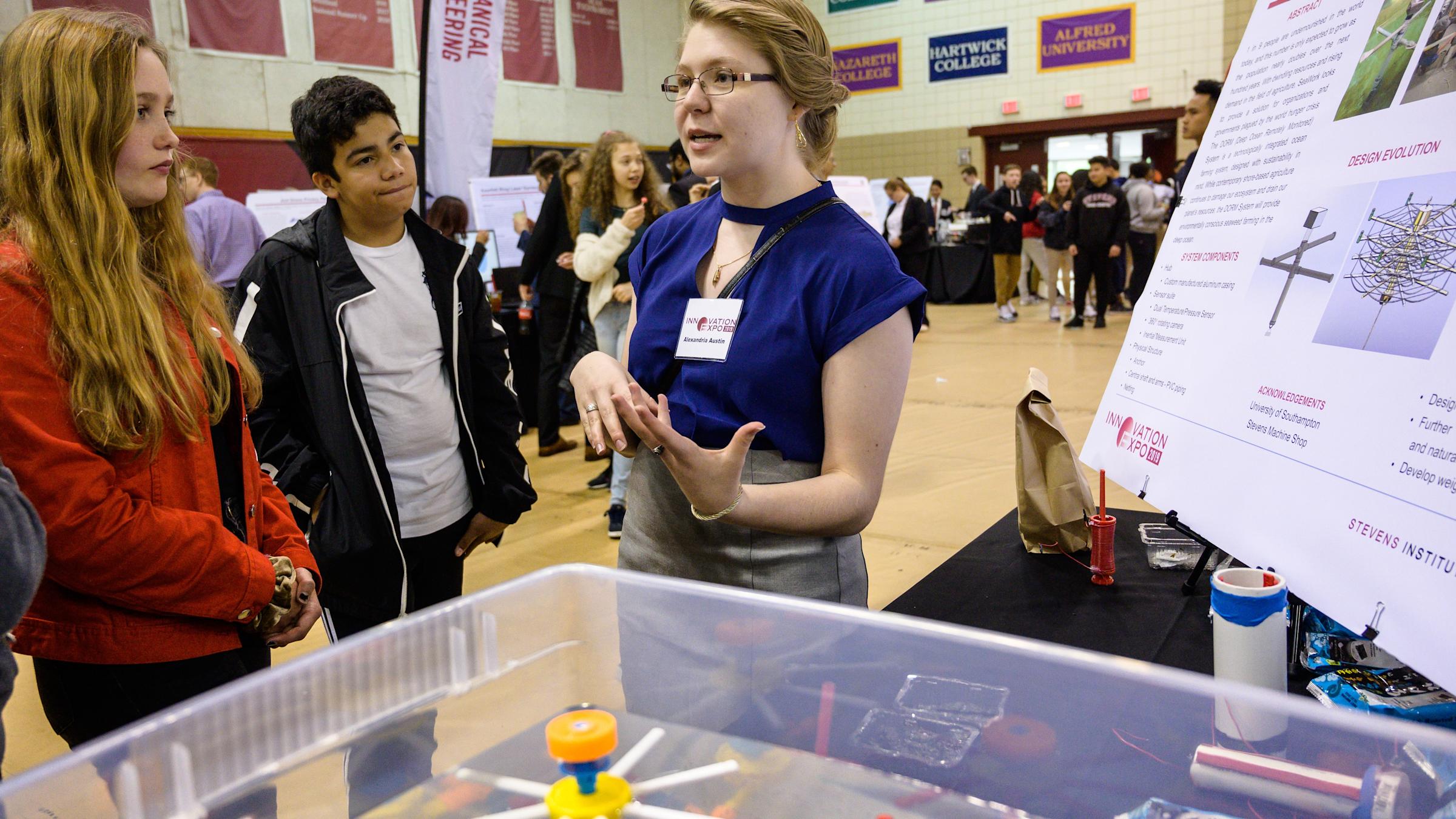 Three female students explaining a project at the Stevens Innovation Expo
