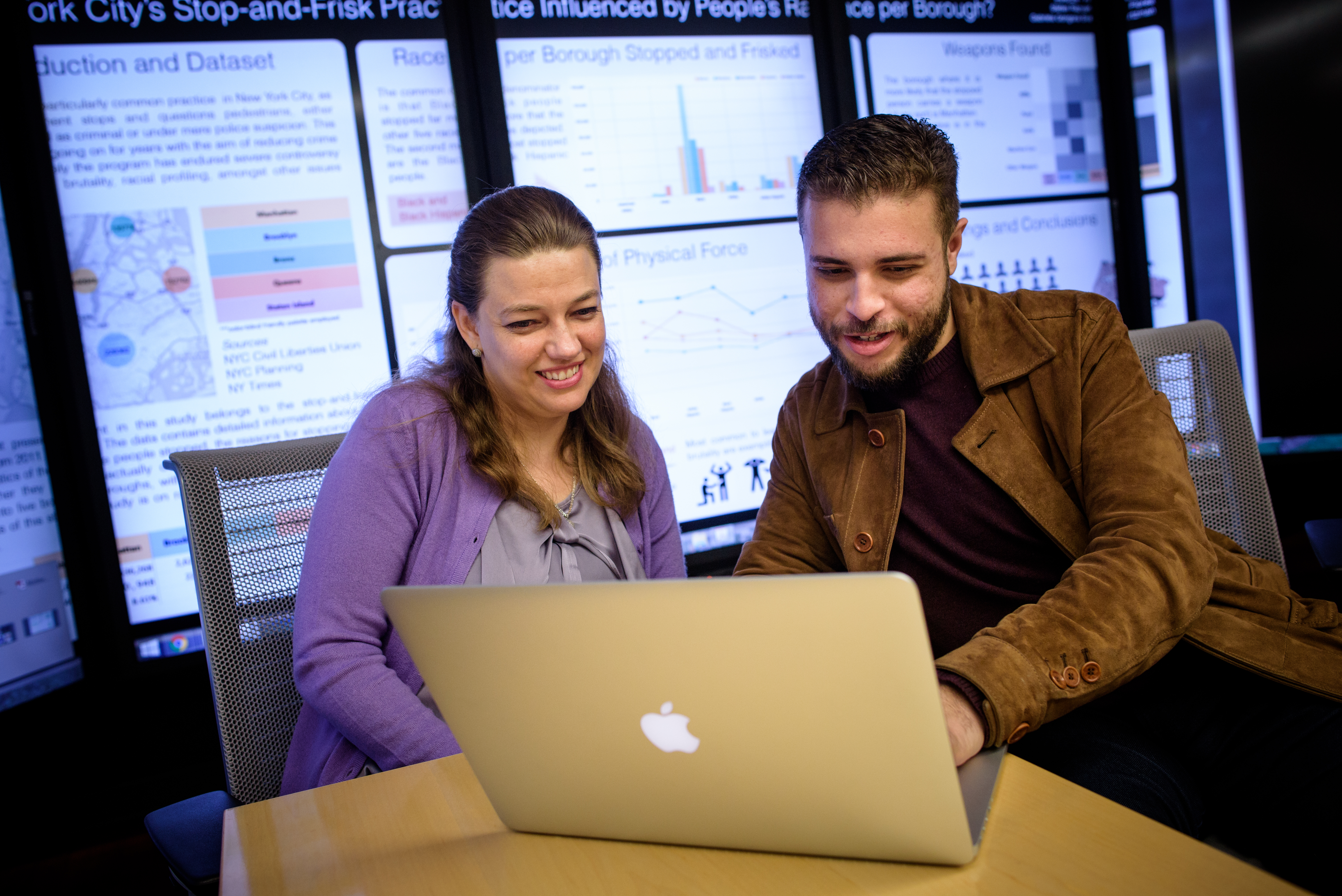 Two students share a laptop.