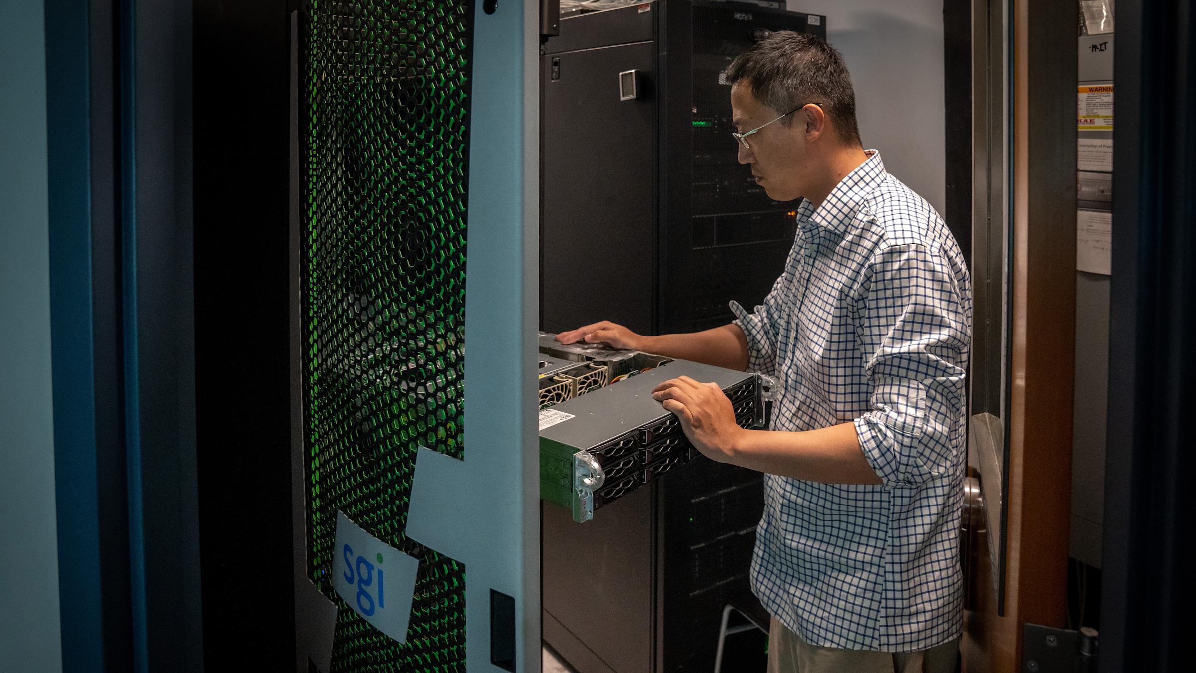 Systems Administrator Zheng Xing examines new Nvidia H100 GPU server from Supermicro