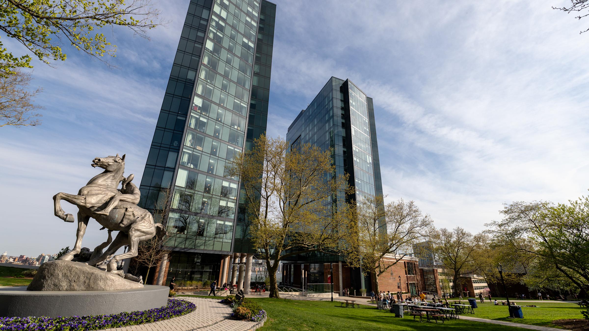 A horse statue in front of two glass skyscrapers
