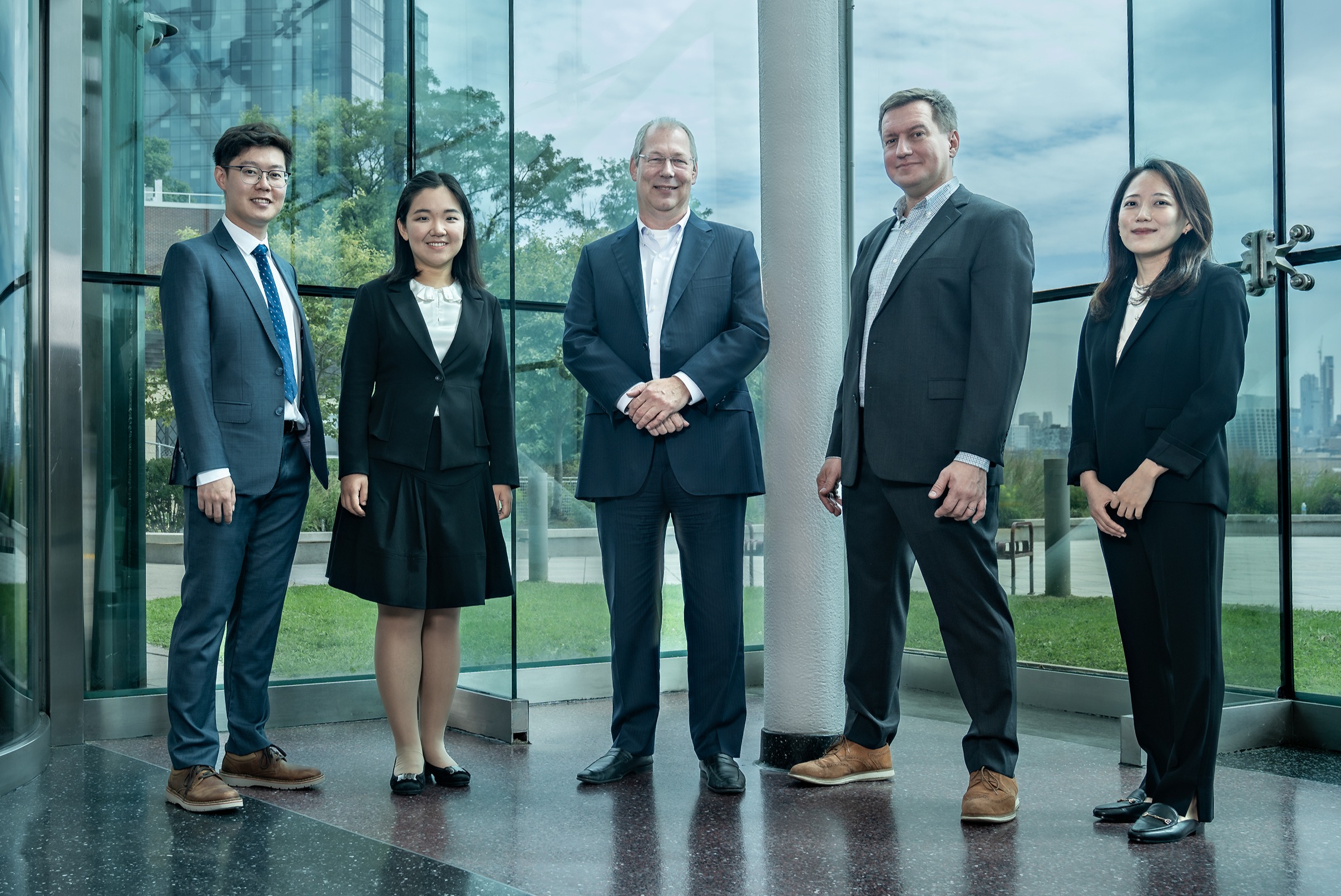 New faculty stands in the lobby of the Babbio Center. 
