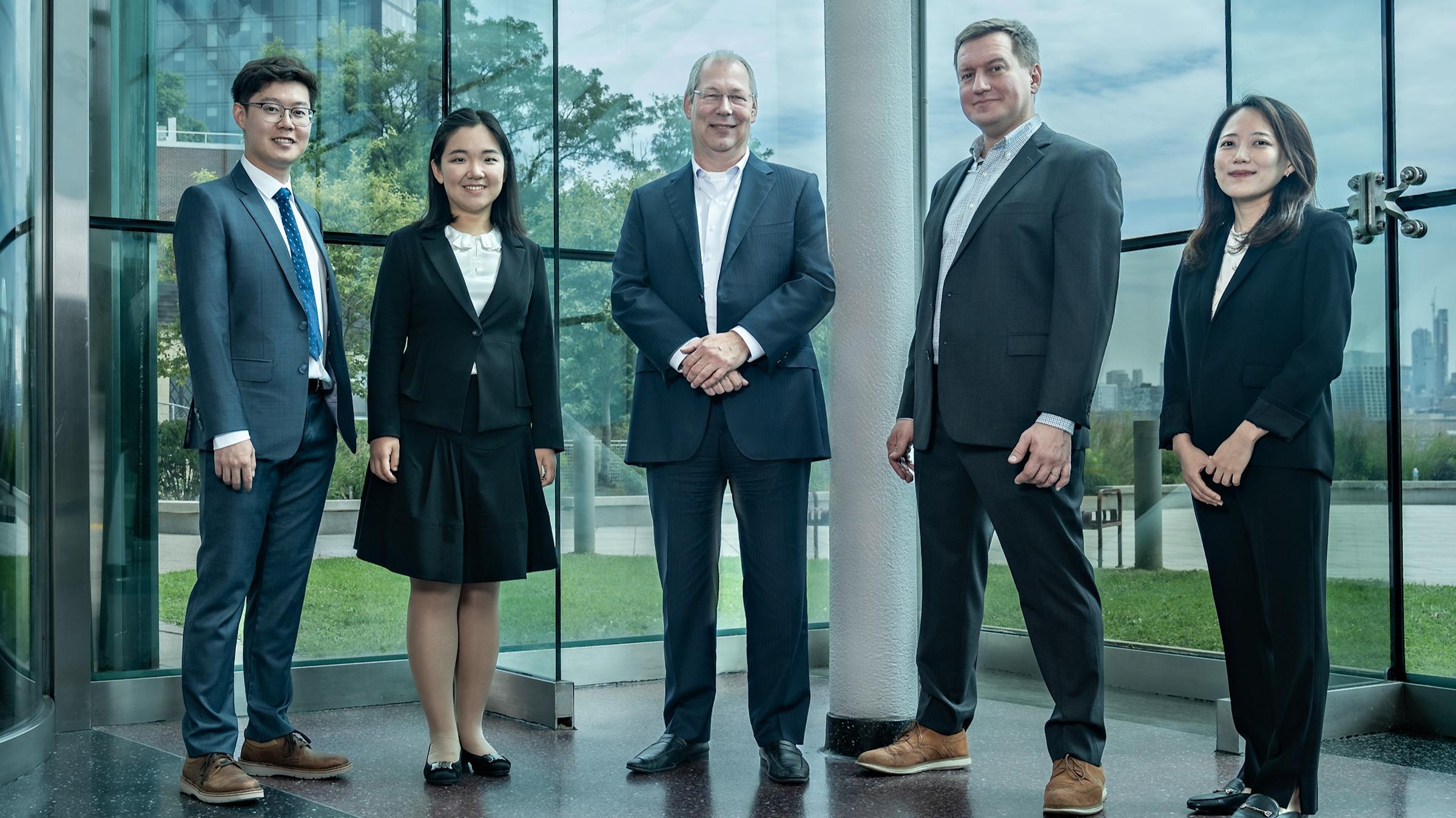 New faculty stands in the lobby of the Babbio Center.