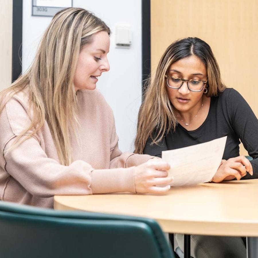 Assistant Director Amy Katzenback assists a student with paperwork