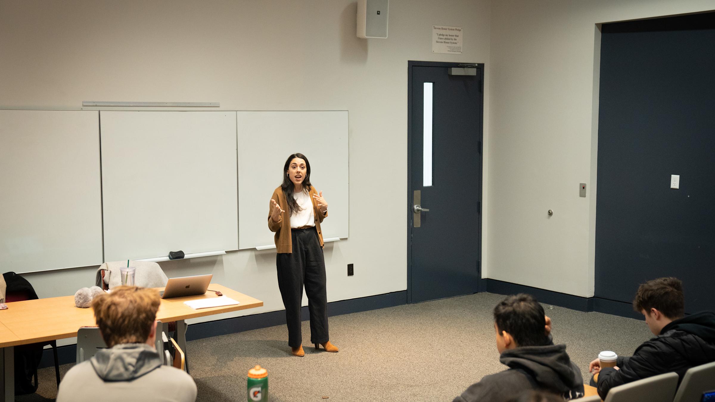 Allie Masciana stands in front of a class and speaks to students.