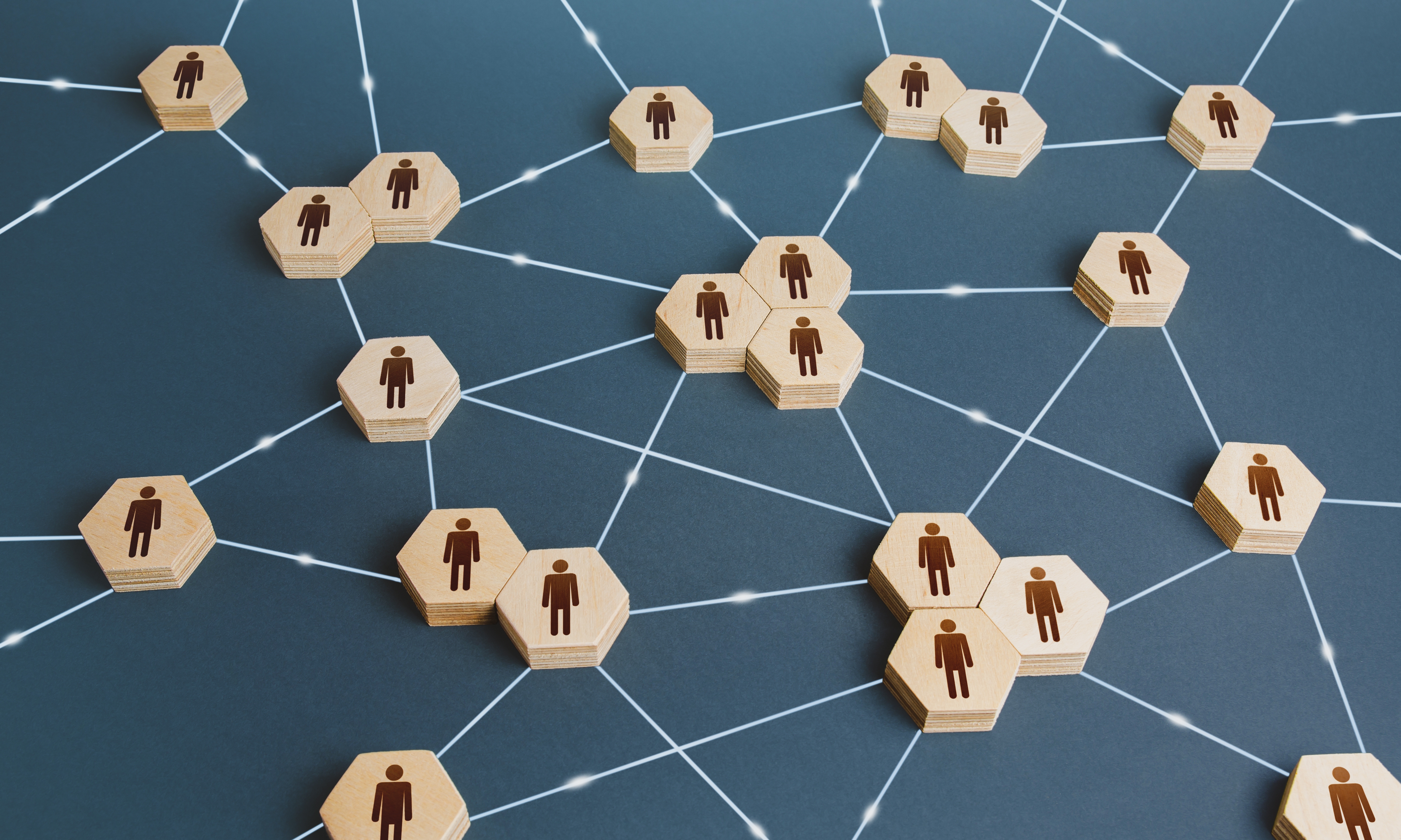 Graphic of wooden disks with people icons connected by lines. Interactions between employees and working groups. Social business connections. Networking communication. Decentralized hierarchical system of company. Organization