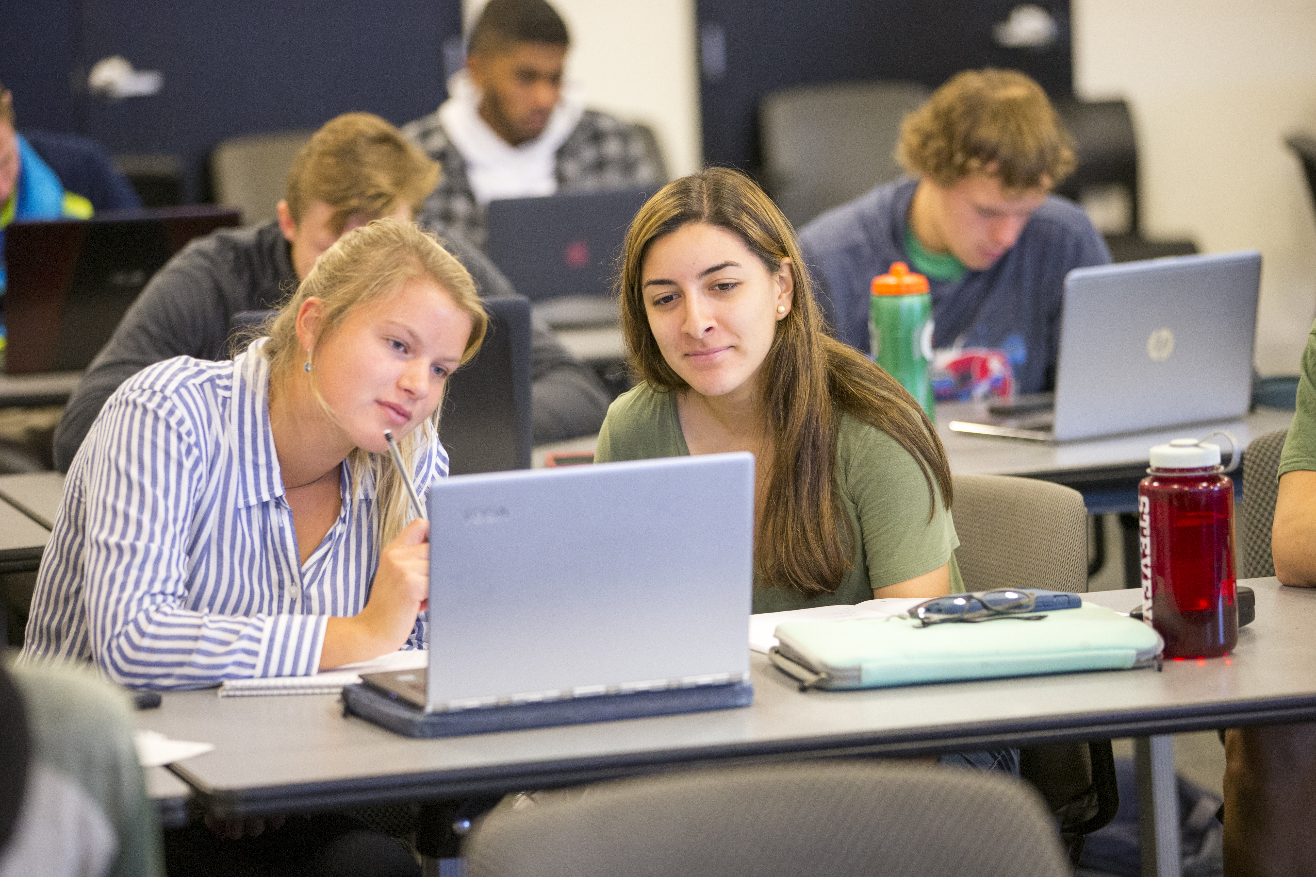 Two students looking at a laptop screen.