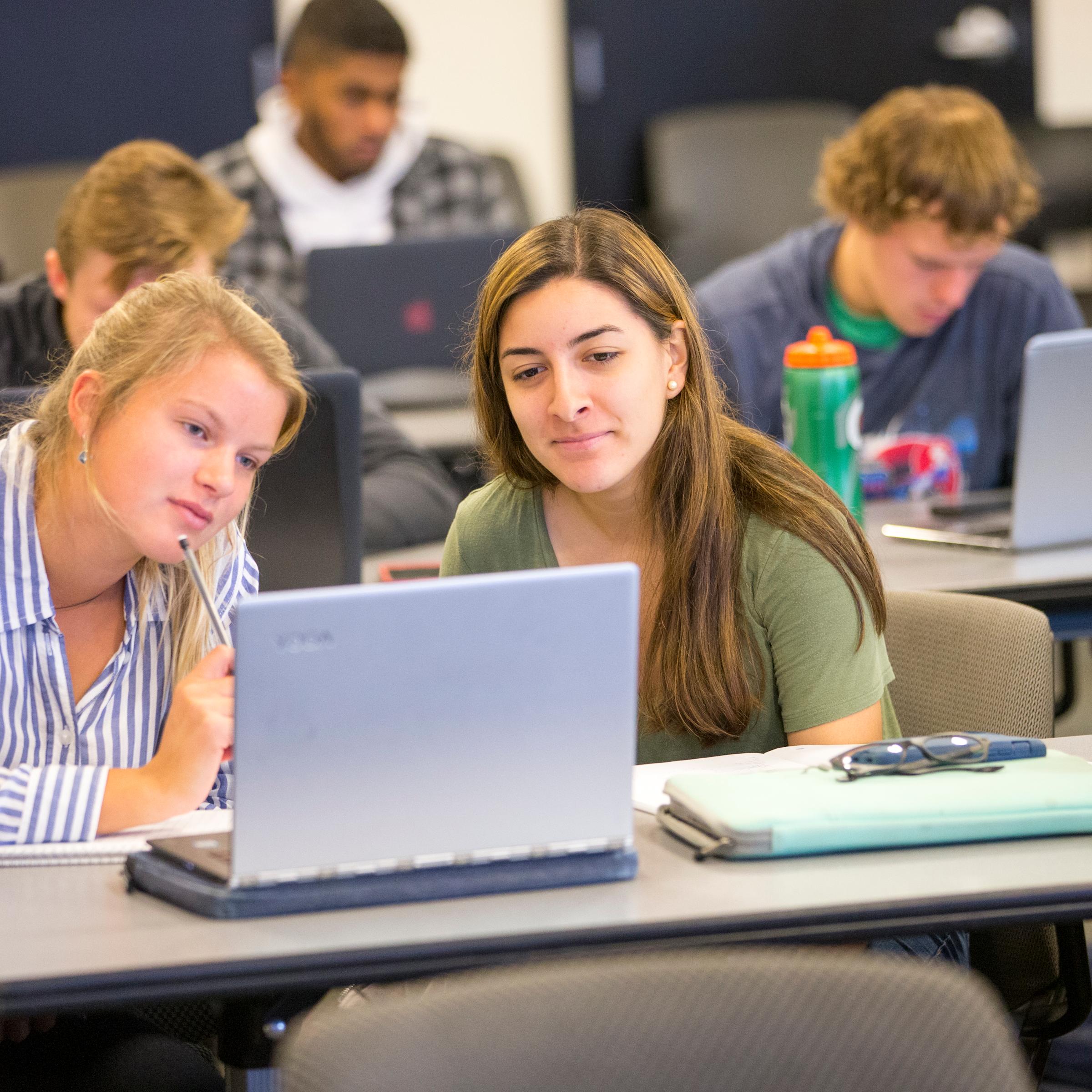 Two students looking at a laptop screen.