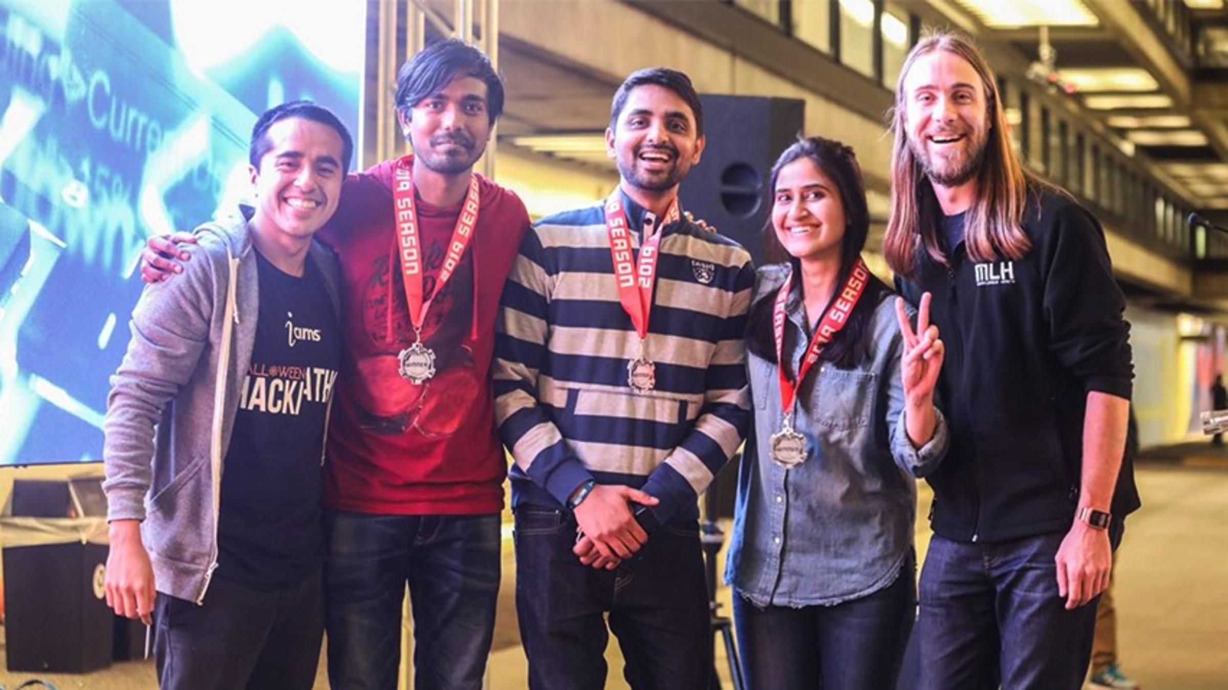 The three winners and two judges pose for a group photo after the hackathon.