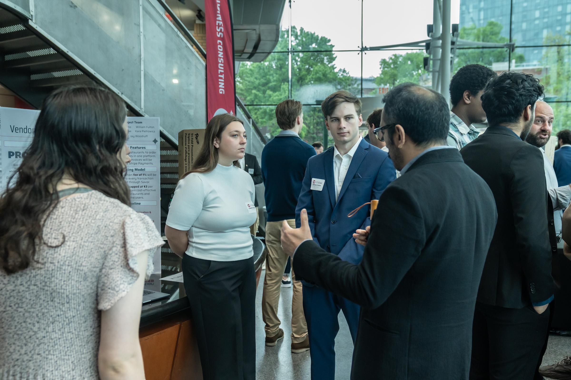 Three students present their project to an onlooker.